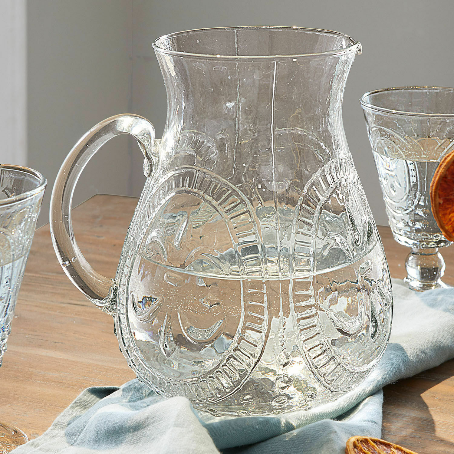 Caraffa Pépin Brocca in vetro trasparente con motivo decorativo su tavolo in legno con tovagliolo