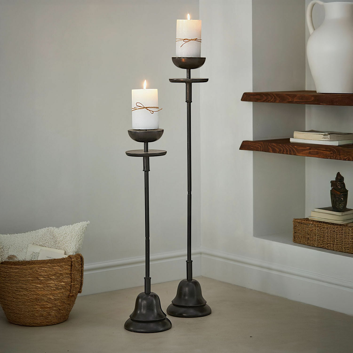 Coppia di portacandele Brantino Due alte candelabri in metallo nero con candele bianche accese, decorazione per interni