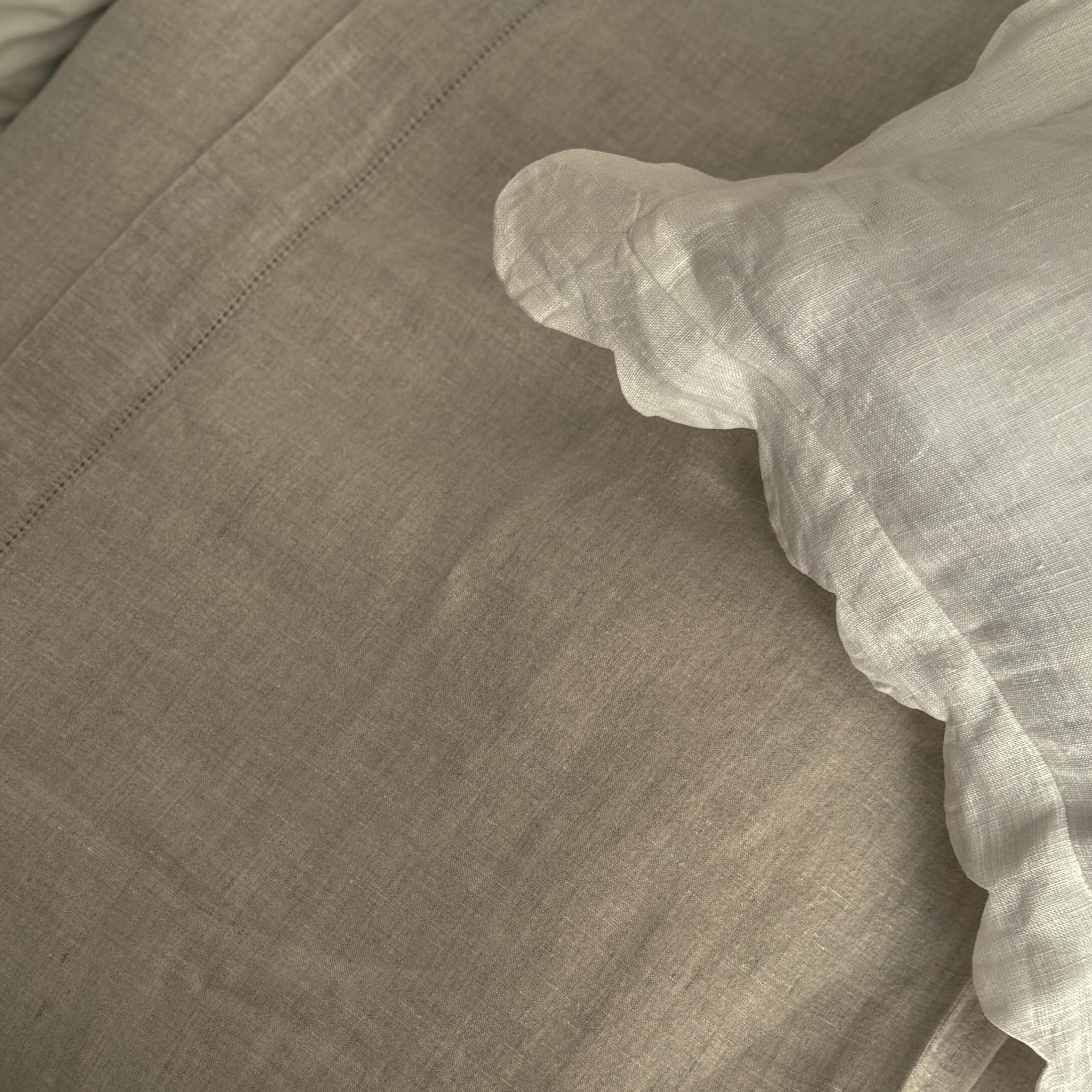 Biancheria da letto beige in lino con bordo bianco arricciato, tessuto naturale per camera da letto