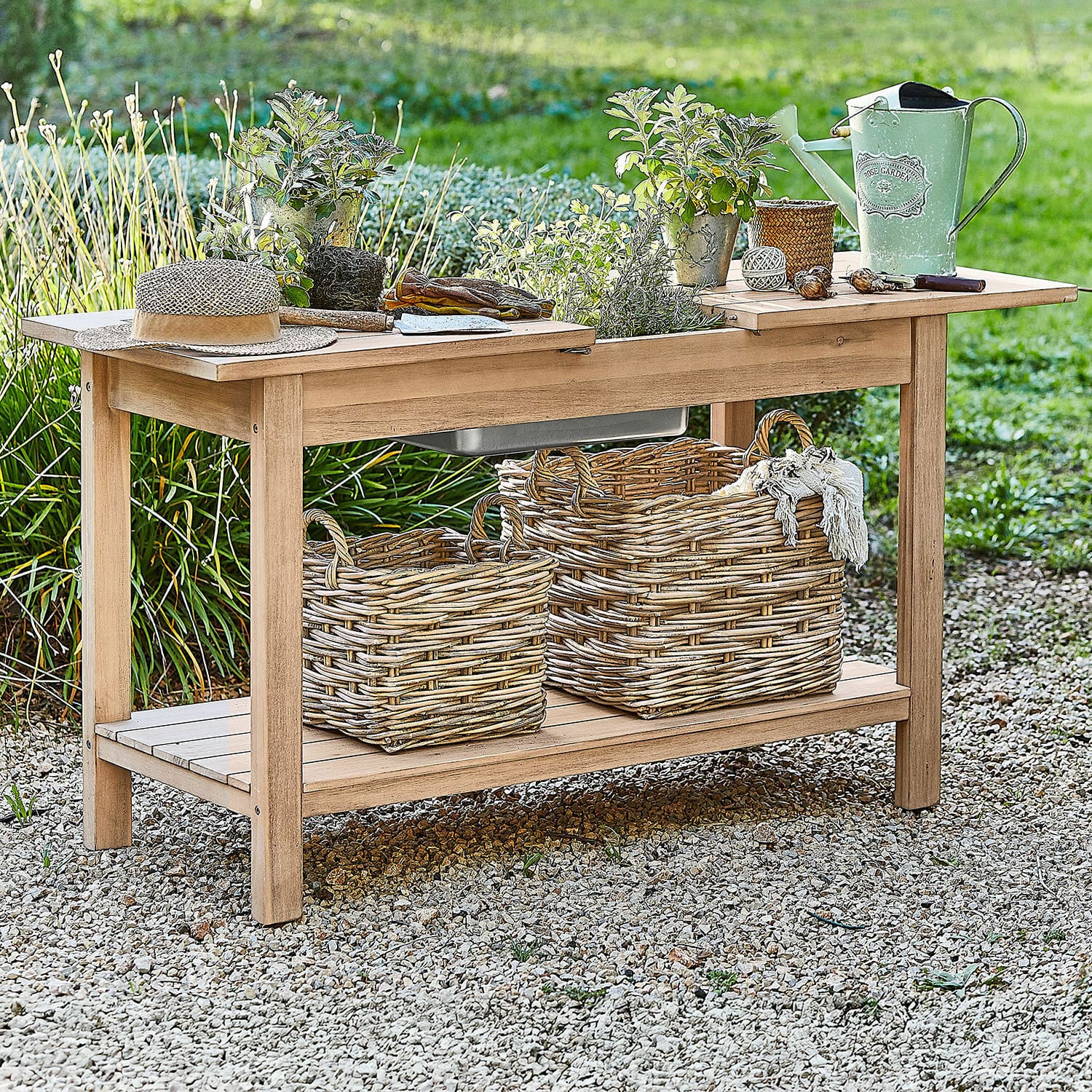 Tavolo per giardinaggio FSC®-100% Venzone Tavolo da giardino in legno con vasi, annaffiatoio verde e cesti di vimini su ghiaia