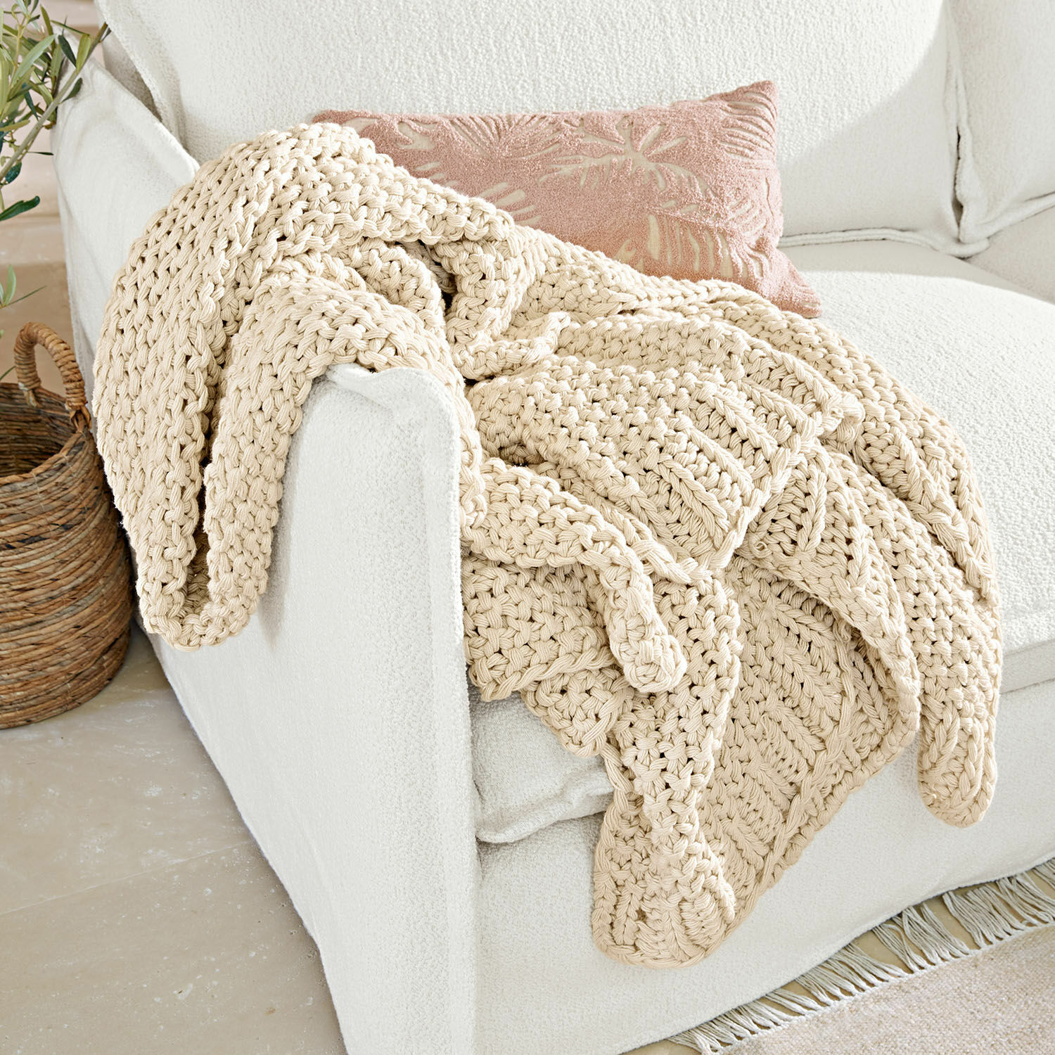 Plaid Plixoren Coperta beige spessa in cotone lavorata a maglia a mano su divano bianco in ambiente luminoso