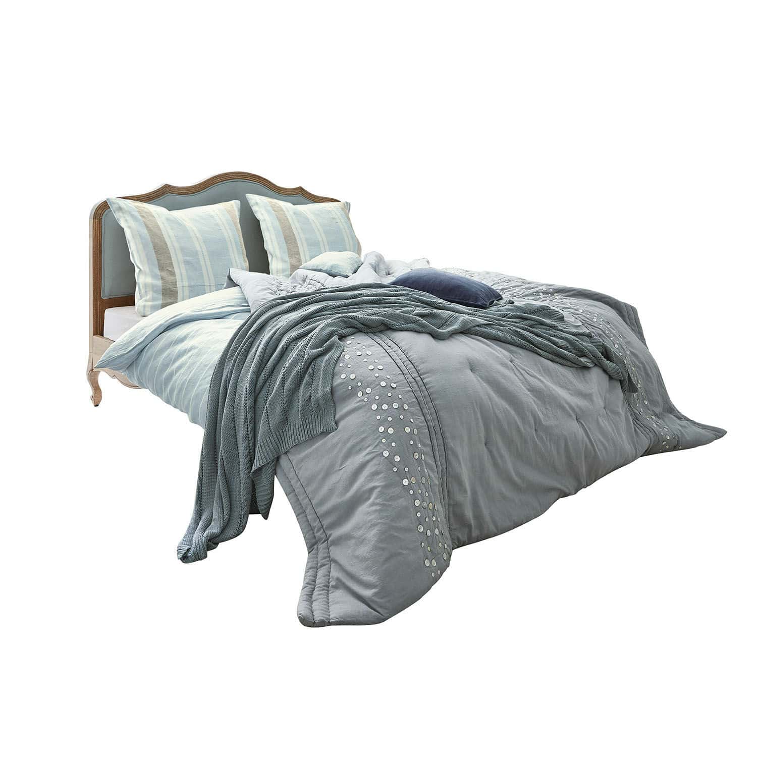 Letto Serravalle Letto con testiera in legno e biancheria da letto blu con cuscini decorativi e coperta lavorata a maglia