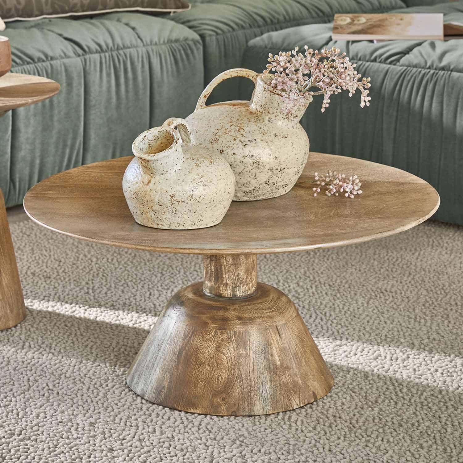 Tavolino in legno con due vasi in ceramica crema dallo stile rustico su tappeto beige