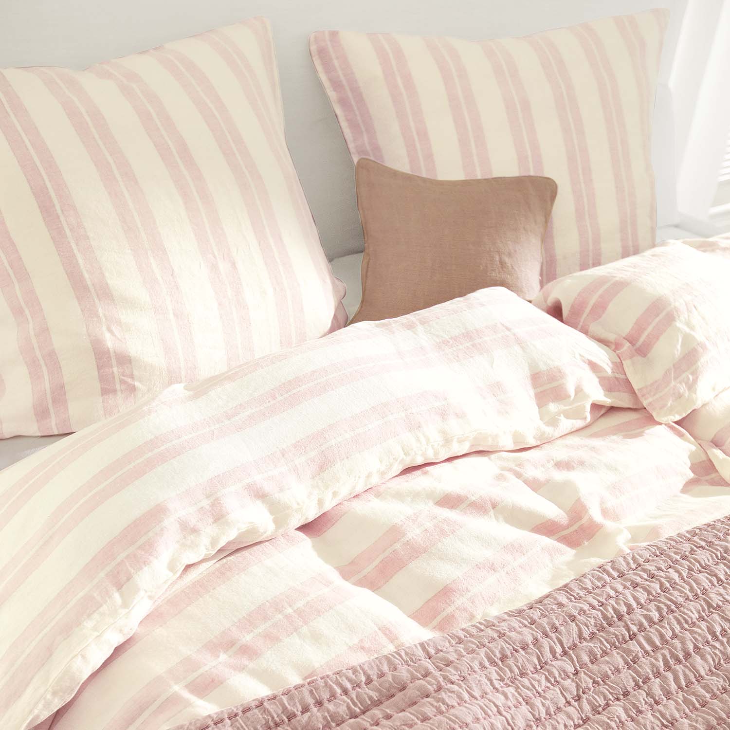 Biancheria da letto e cuscini in cotone a righe crema e rosa con coperta rosa morbida e accogliente