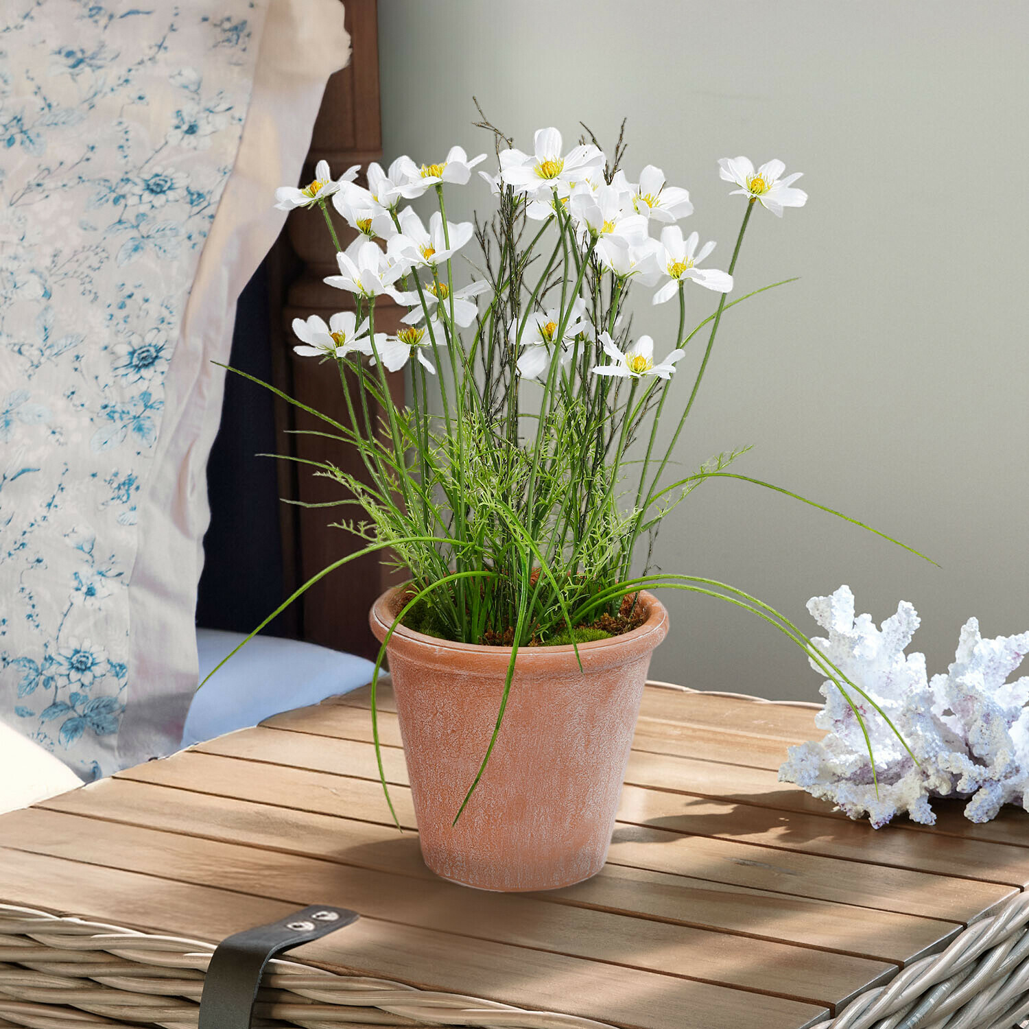 Fiori bianchi in vaso di terracotta su tavolo in legno, decorazione d'interni con foglie verdi