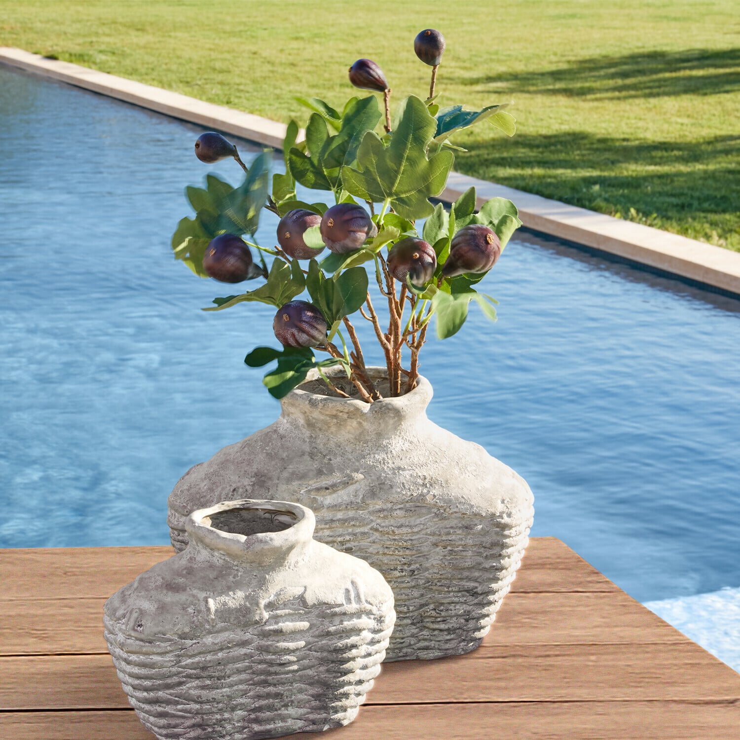 Set di 3 rami decorativi Alverino Due anfore rustiche in ceramica grigia su tavolo in legno vicino piscina con foglie verdi e frutti