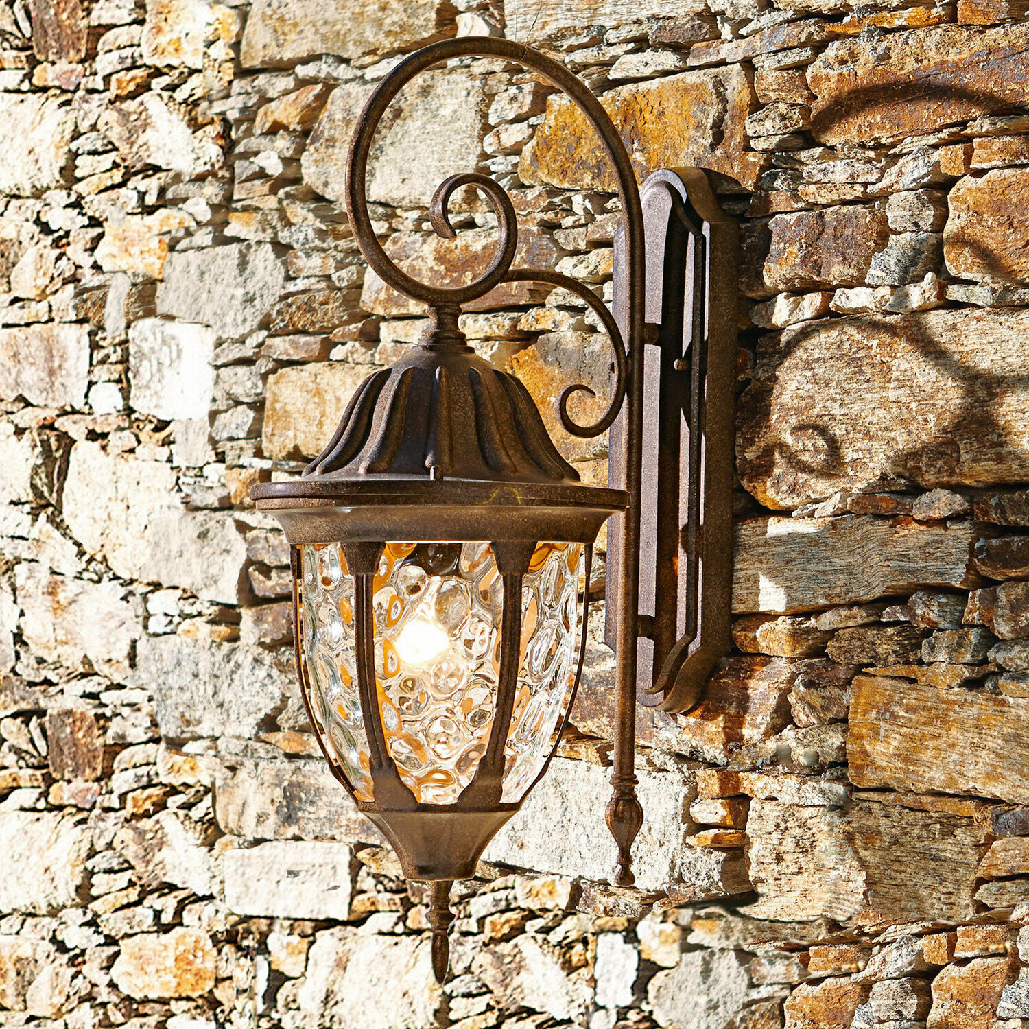 Lampada da parete per esterno Herrère Applique rustica in metallo arrugginito con vetro decorativo su muro in pietra