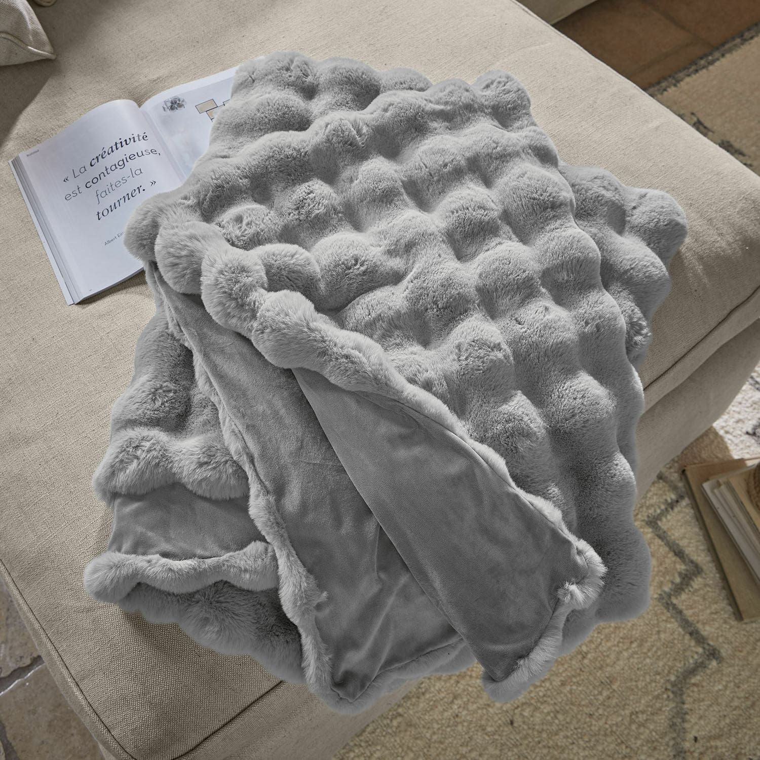 Coperta Zalina Morbida coperta grigia con motivo pelliccia su divano beige, ideale per decorare e riscaldare l'ambiente
