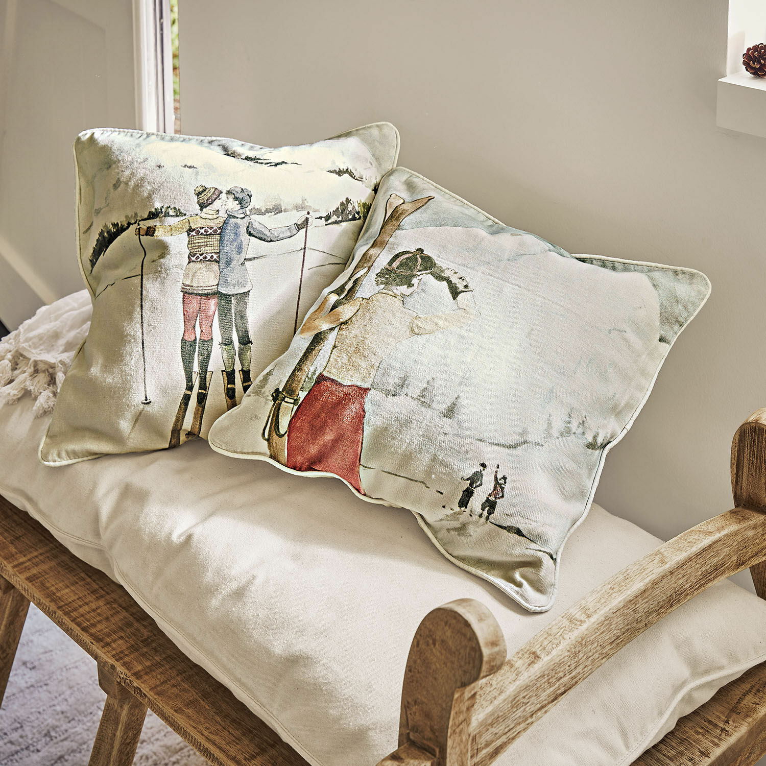 Coppia di copricuscini Towyn Cuscini decorativi con motivo sci invernale su tessuto chiaro su panca in legno