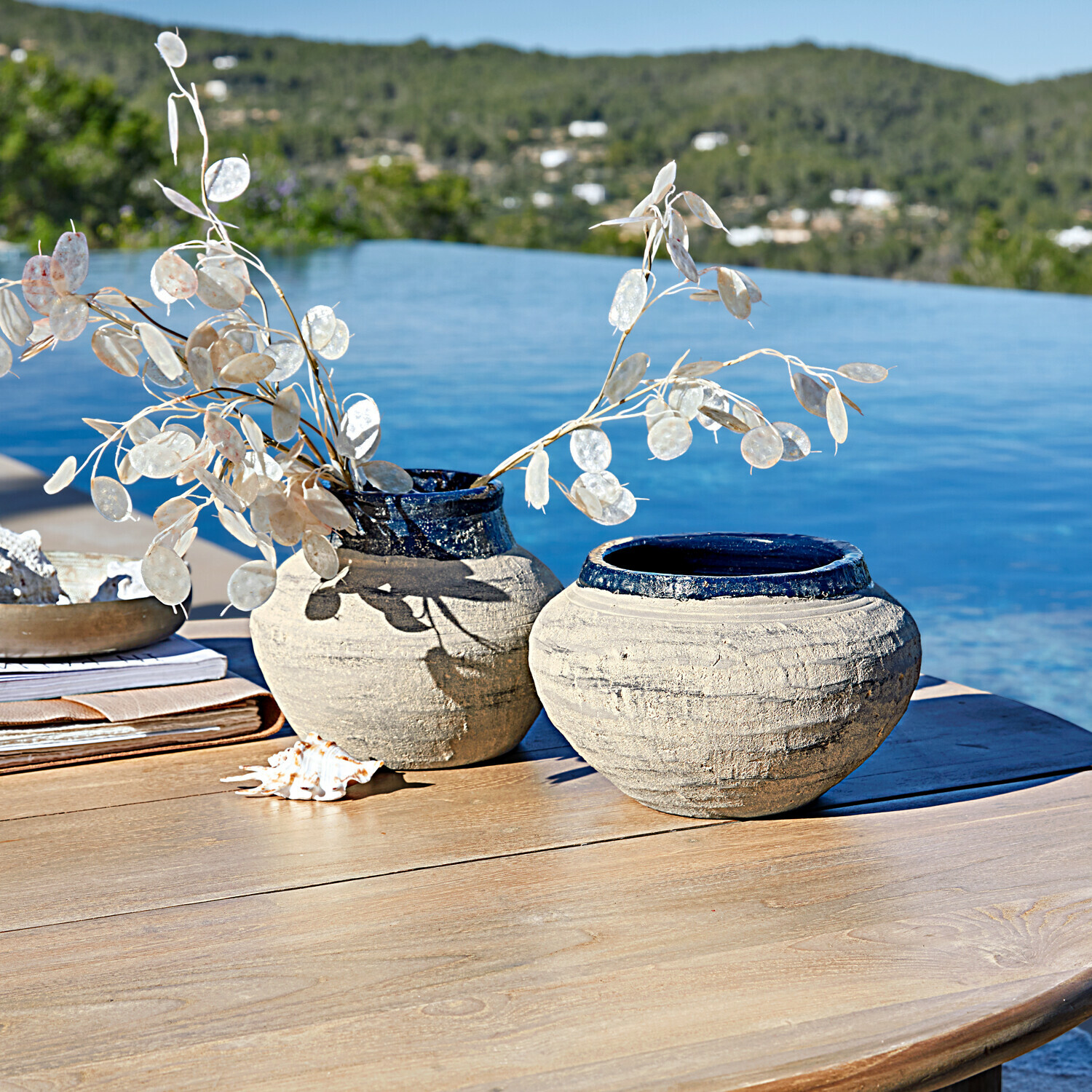 Coppia di vasi Dolciaro Due vasi in ceramica beige con bordo blu su tavolo in legno vicino alla piscina