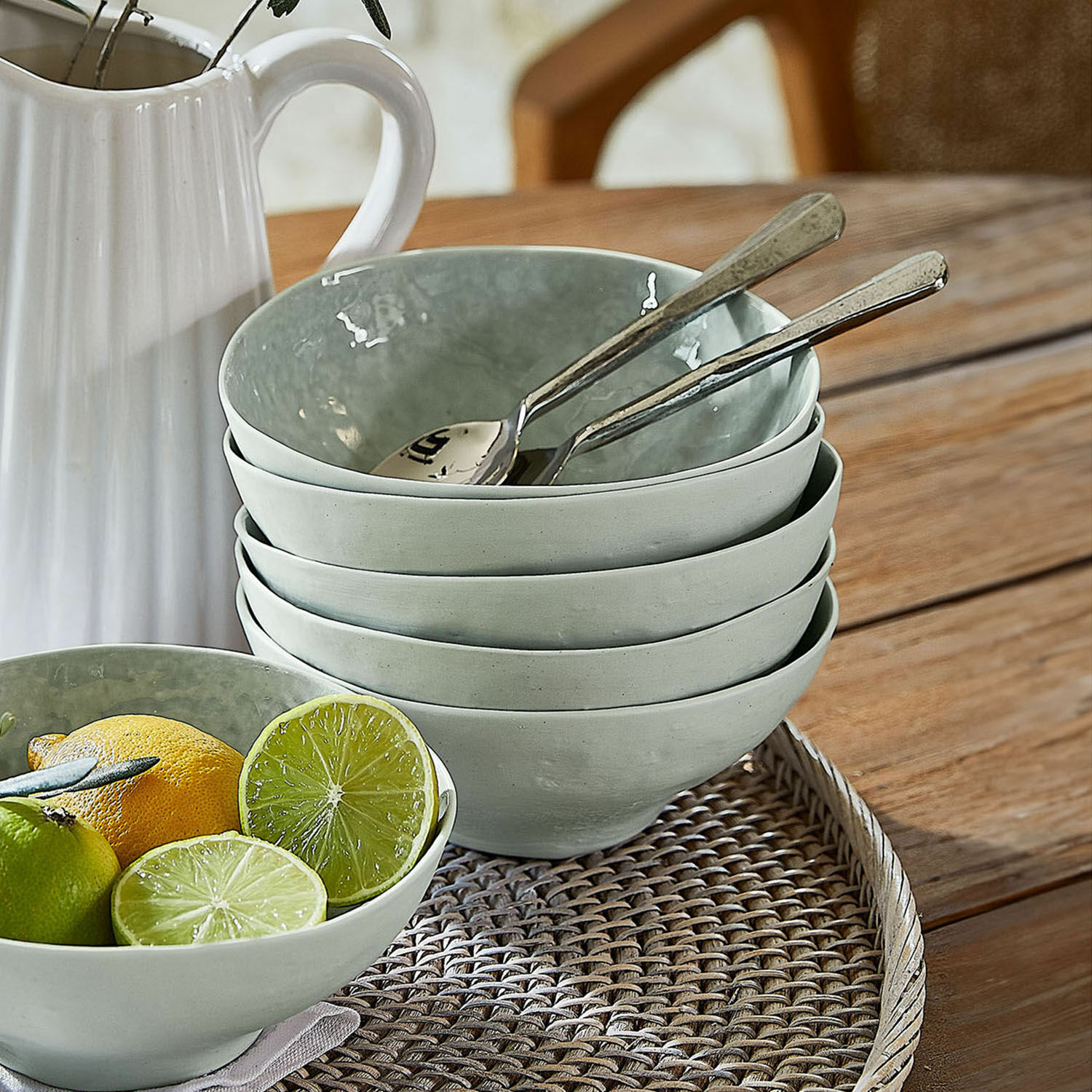 Set di 6 ciotole Braganza Set di ciotole in ceramica grigia su vassoio intrecciato con frutta e cucchiai