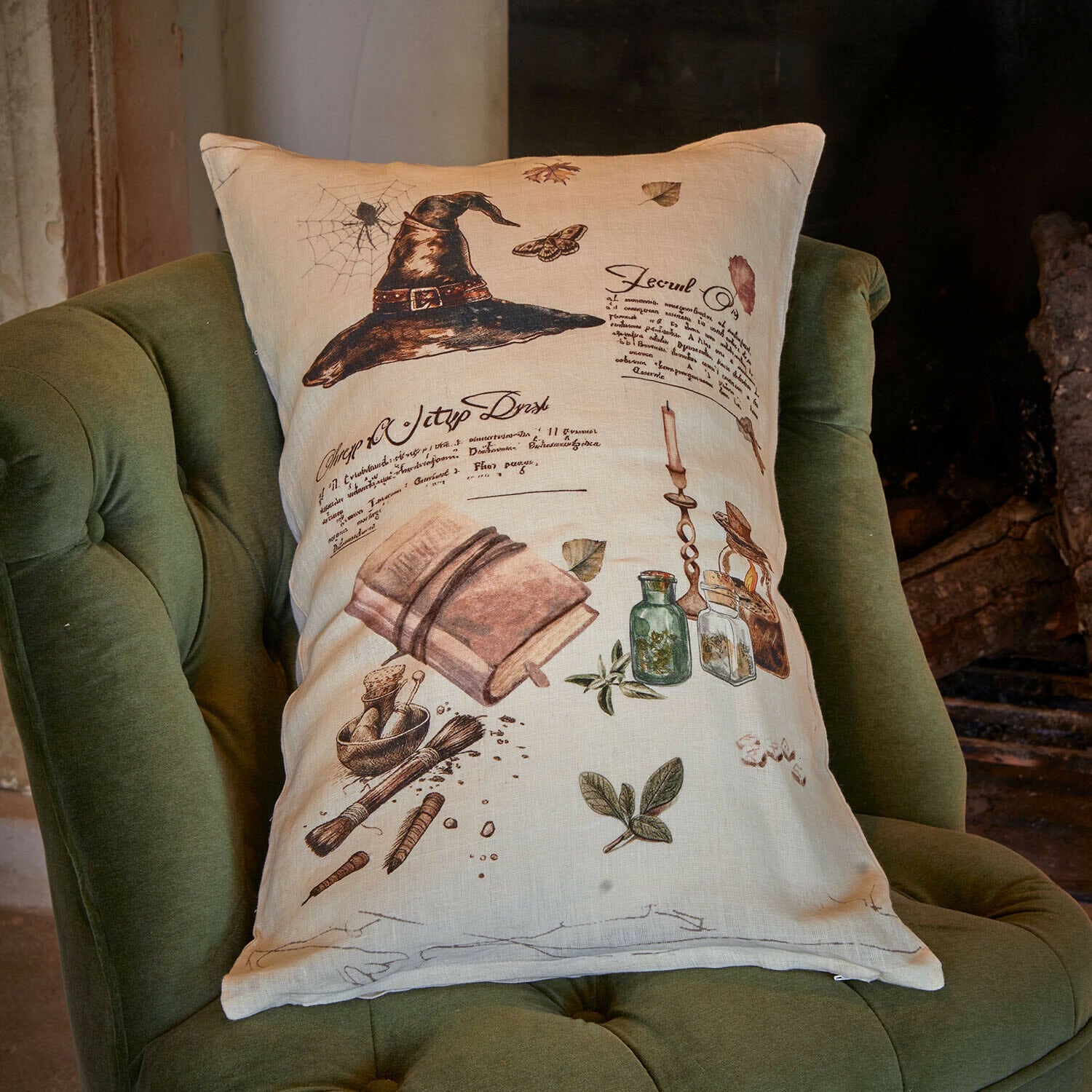 Copricuscino Maerlinna Cuscino in lino beige con stampa di cappello nero, libro ed erbe su poltrona verde