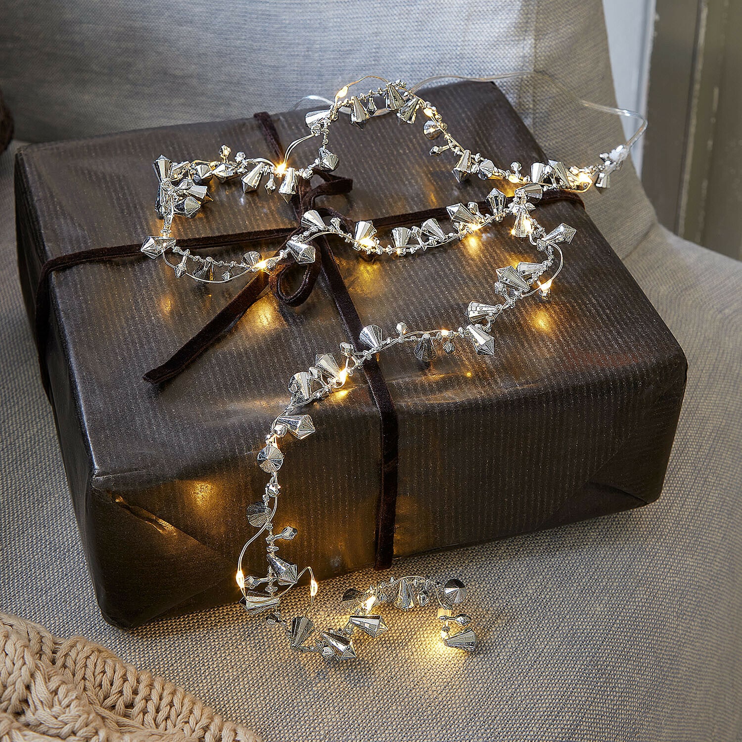 Luci di fata Bryesa Catena luminosa delicata con decorazioni metalliche argento su pacco regalo scuro