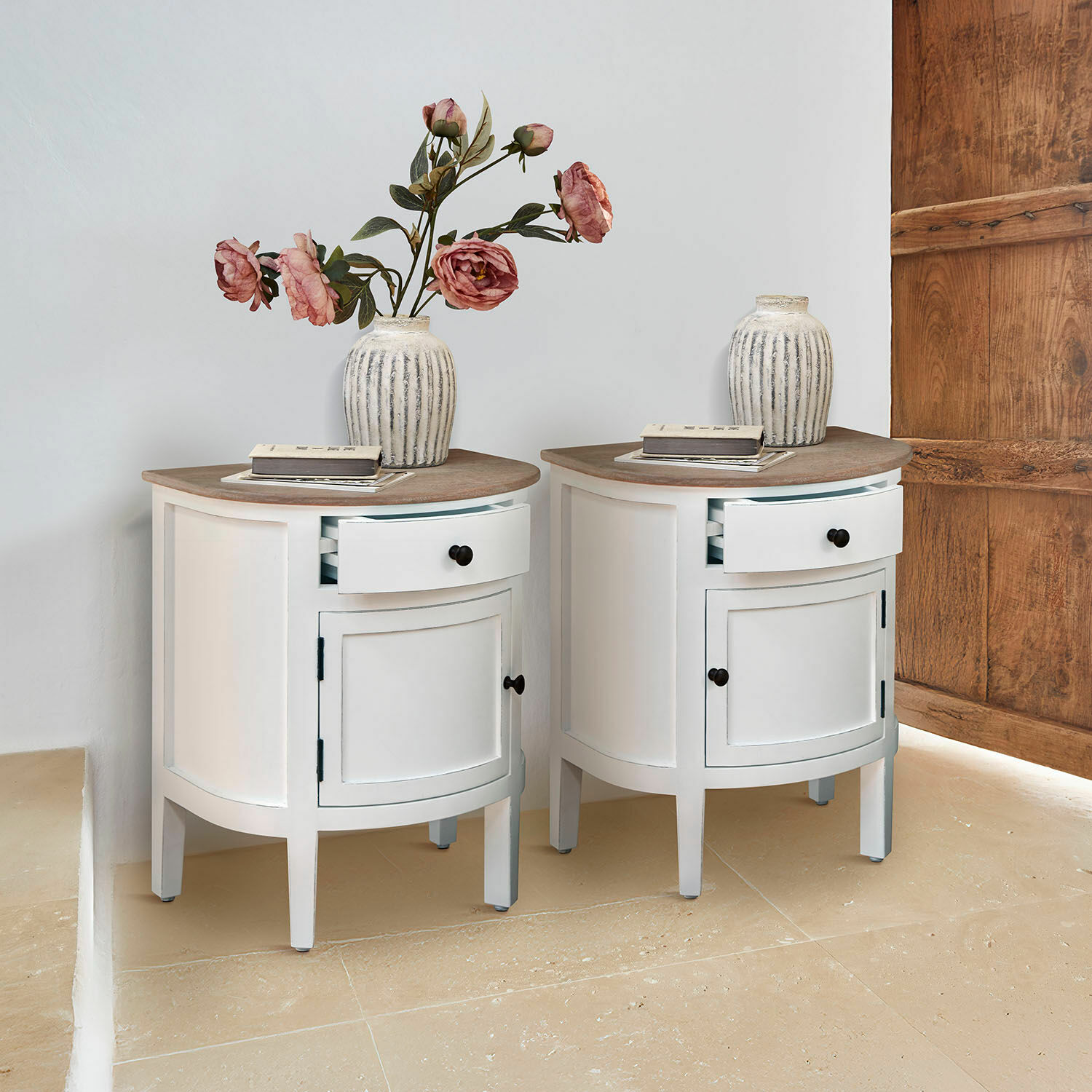 Coppia di comodini Arvelin Coppia di comodini bianchi in legno con piano semicircolare e vaso decorativo con fiori