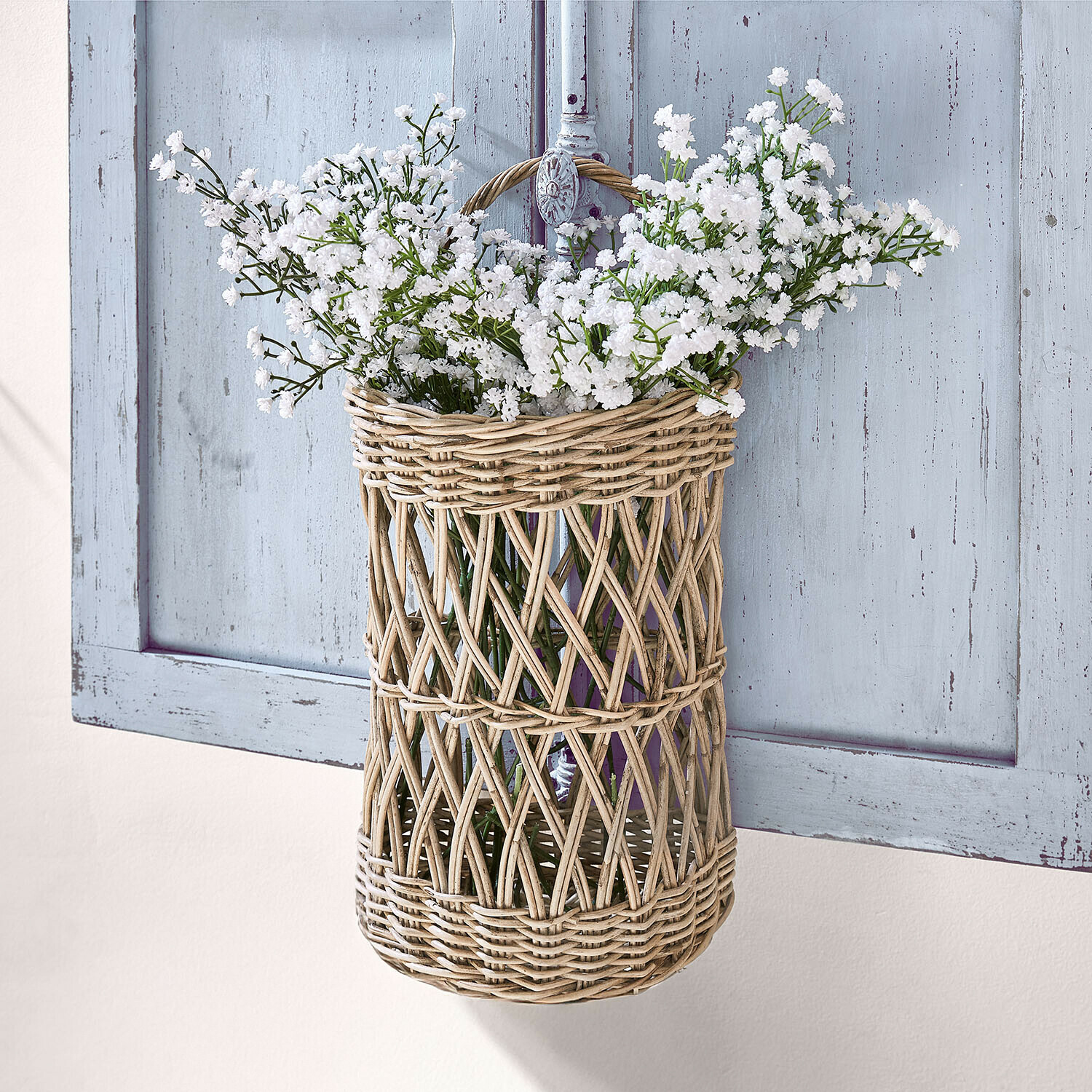 Cesto sospeso in rattan naturale con fiori bianchi per decorazione da parete