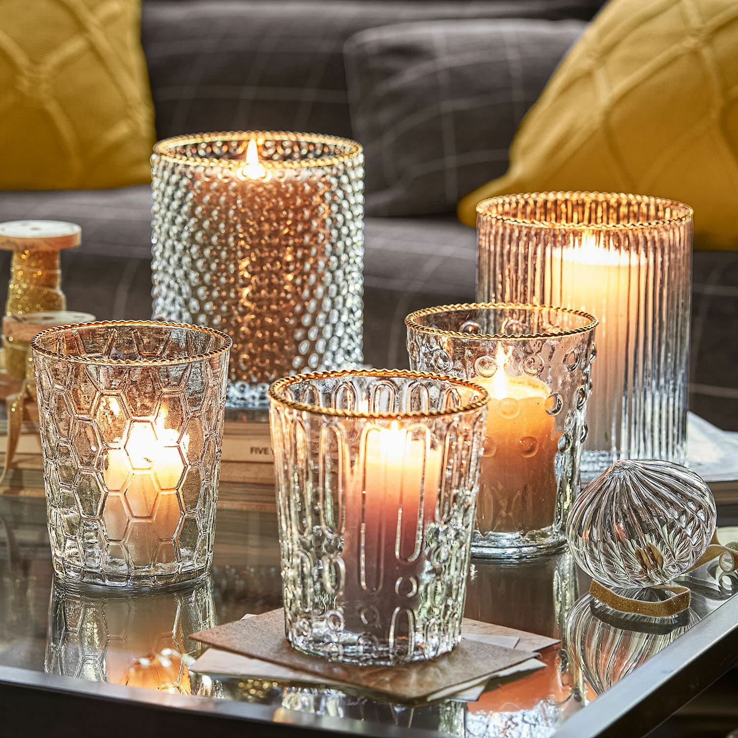 Set di 5 portalumini Rosienne Portacandele in vetro con texture diverse e bordi dorati su tavolo in vetro in soggiorno