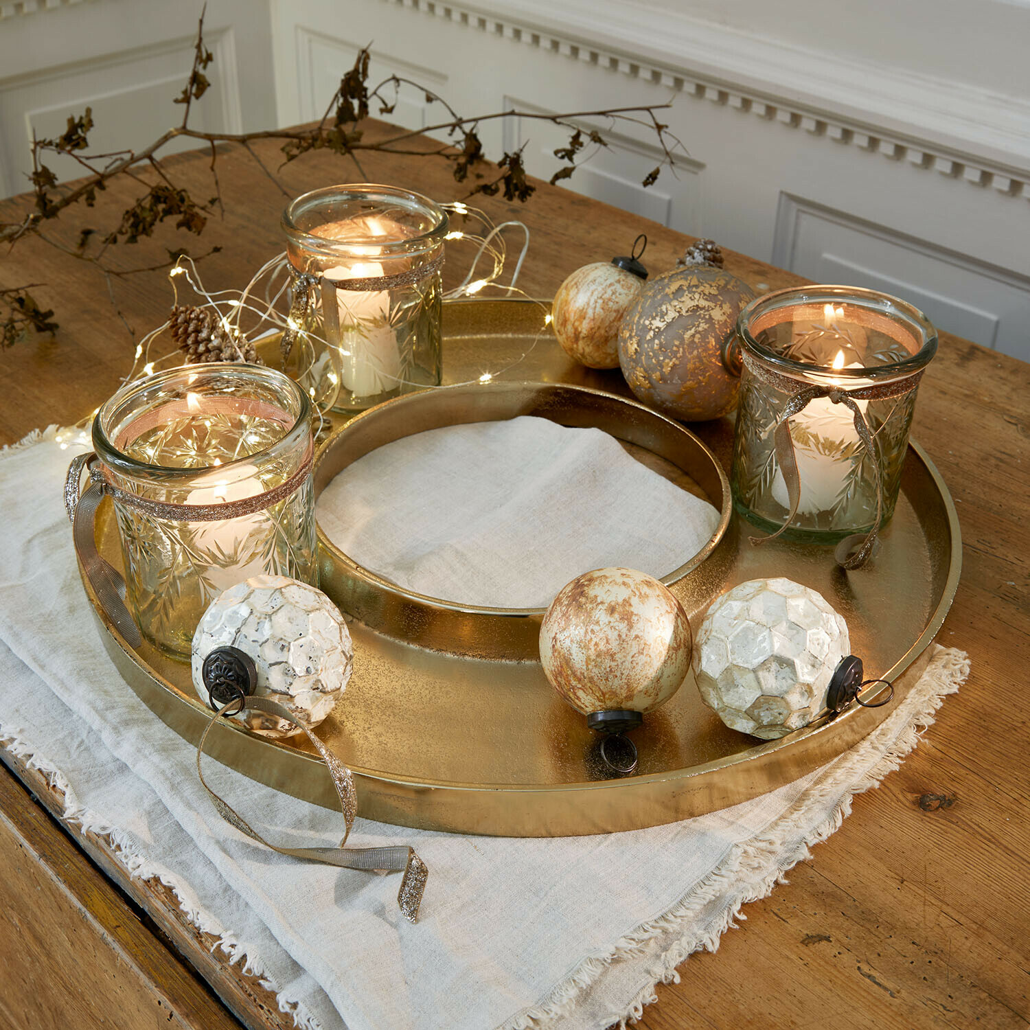 Vassoio per candele Velarosas Vassoio in metallo dorato con tre portacandele in vetro e sfere decorative su tavolo in legno