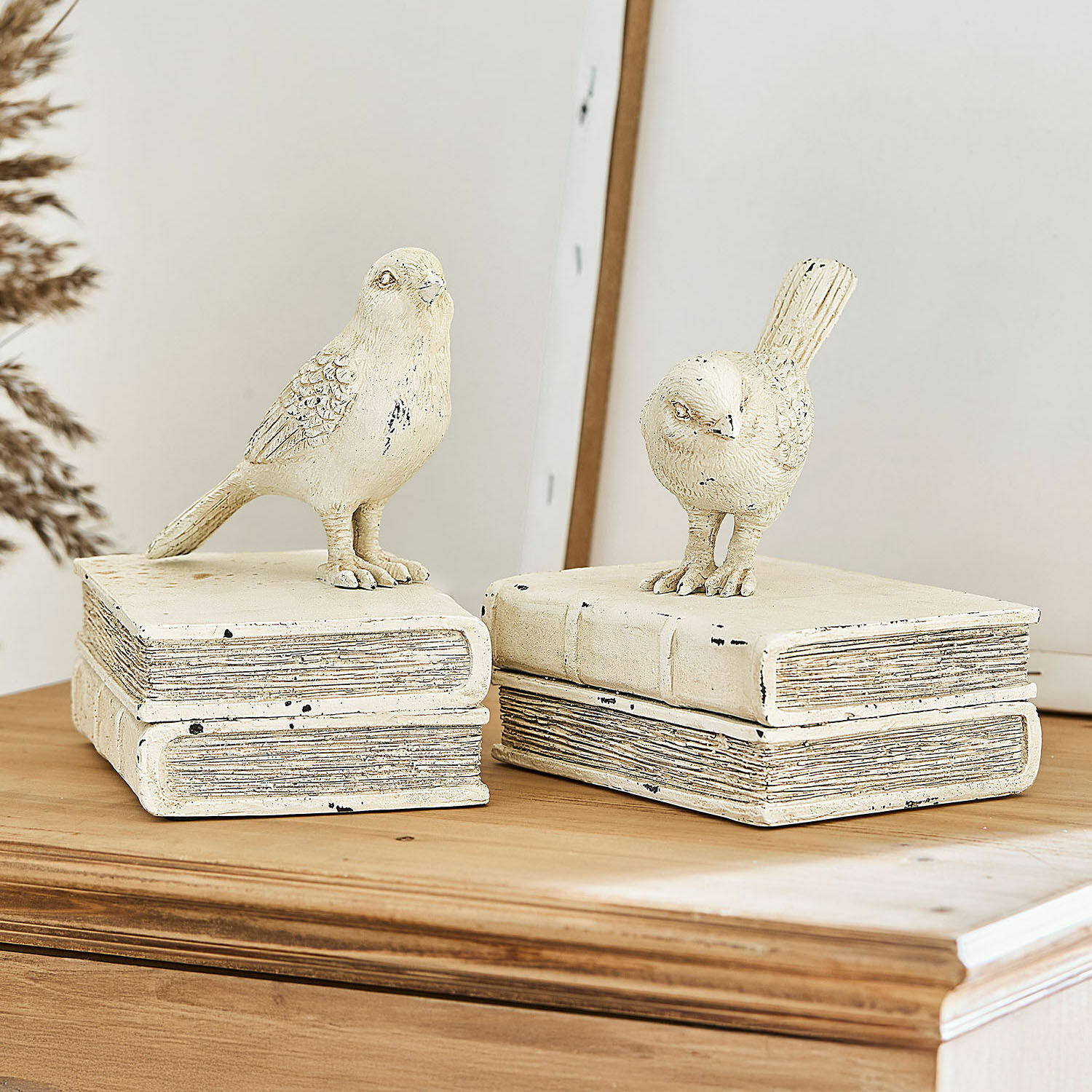 Coppia di figure decorative Moonlet Figure decorative di uccelli in materiale color crema su pila di libri su piano in legno