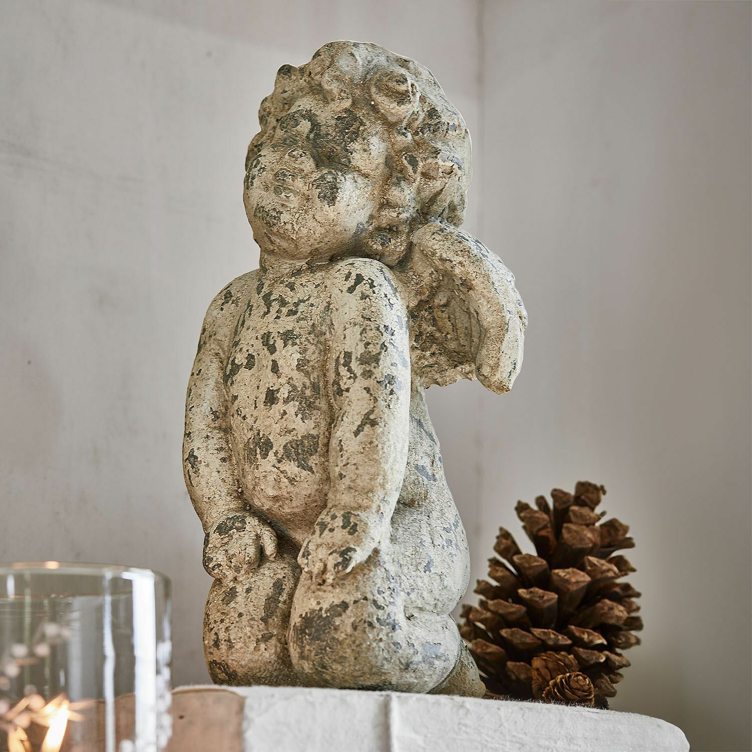 Angioletto decorativo Mines Statua di angelo in pietra invecchiata beige, decorazione d'interni con pigna naturale
