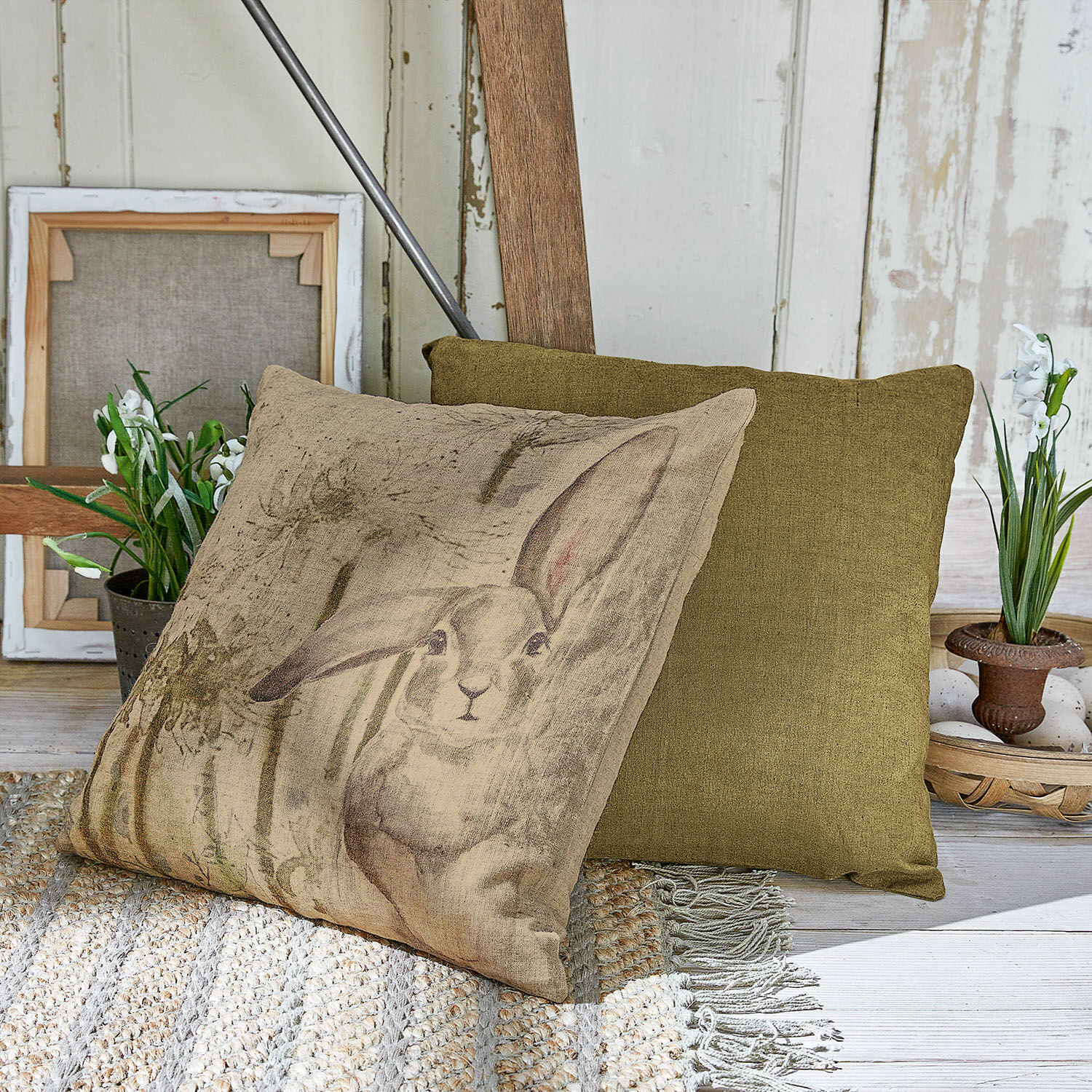 Coppia di copricuscini Milda Cuscino beige con stampa coniglio e cuscino decorativo verde su tappeto intrecciato