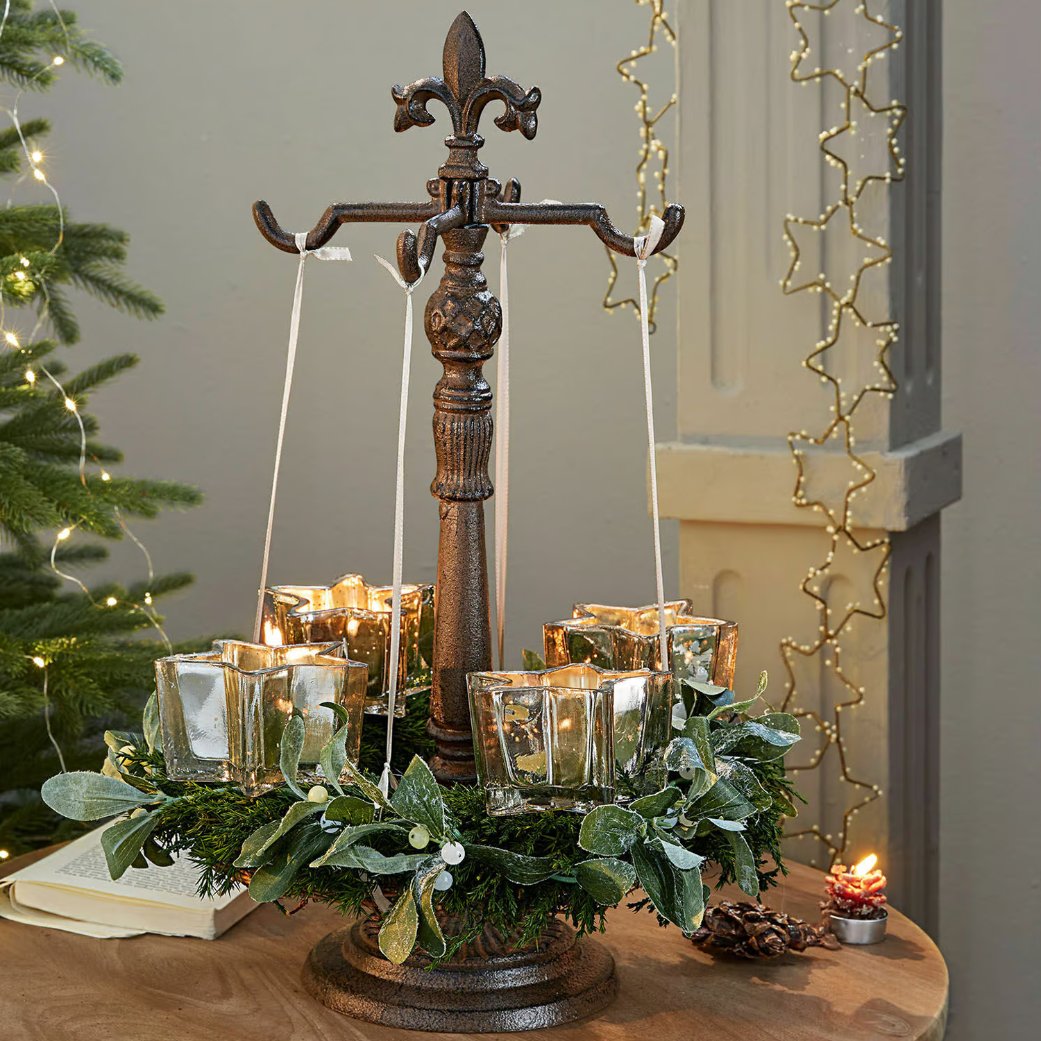 Supporto in metallo con quattro portacandele in vetro a forma di stella sospesi e corona verde decorativa