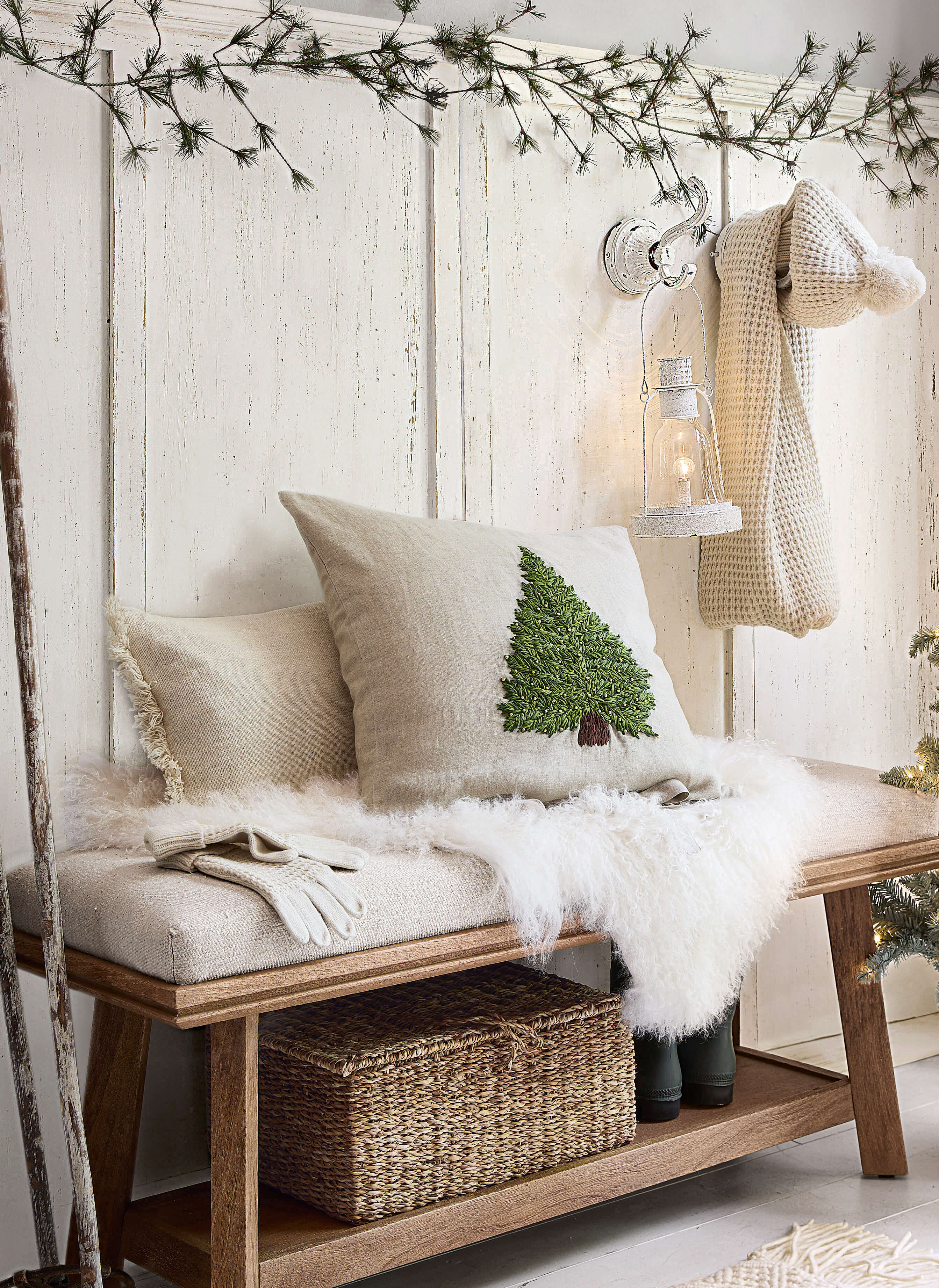 Panca in legno con cuscino beige e cuscino decorativo con albero verde, decorazione invernale per interni