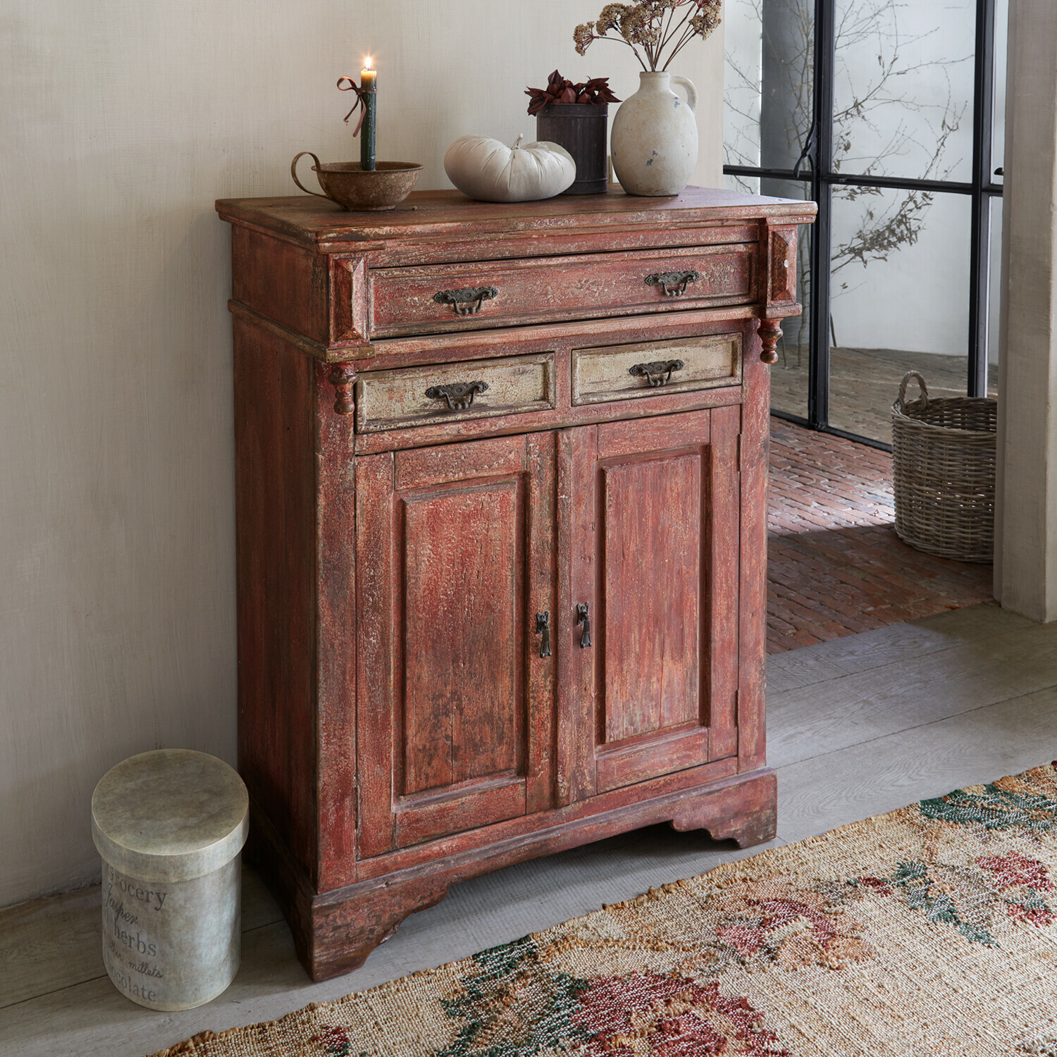 Cassettiera Jolivarne Credenza rustica in legno rosso con maniglie decorative e oggetti decorativi sopra