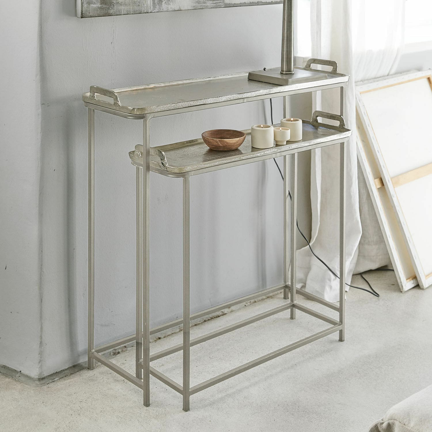 Set di due tavolini in metallo argento con vassoi e decorazioni in interno moderno
