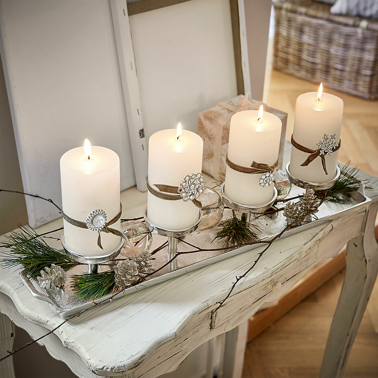 Vassoio portacandele Indila Portacandele decorativo con quattro candele bianche e decorazioni di pigne e rami su tavolo