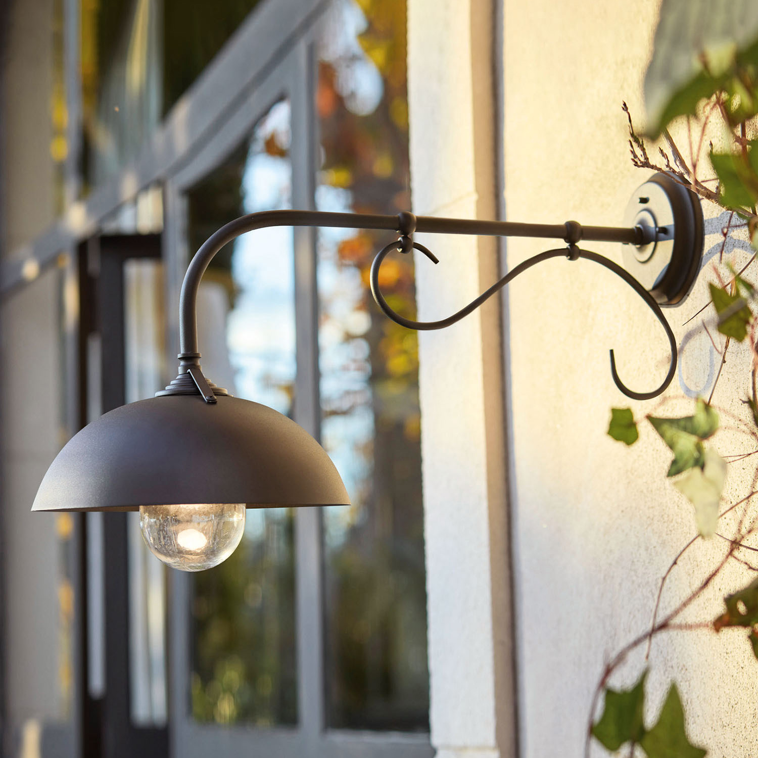 Applique da parete nera in metallo con paralume semicircolare e lampadina in vetro per esterni