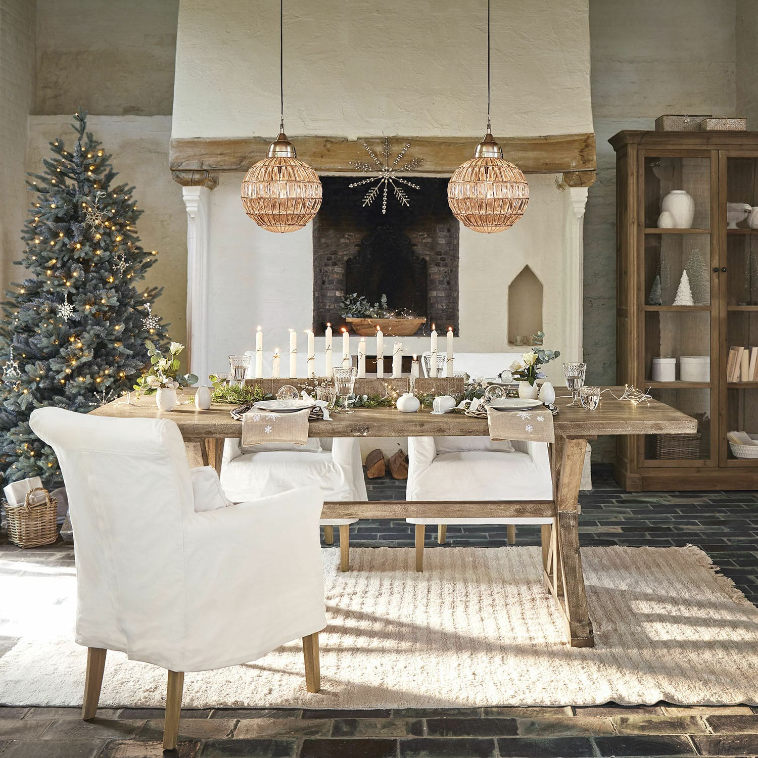 Tavolo da pranzo Dolignon Tavolo rustico in legno con sedie bianche e decorazioni natalizie in soggiorno accogliente con camino
