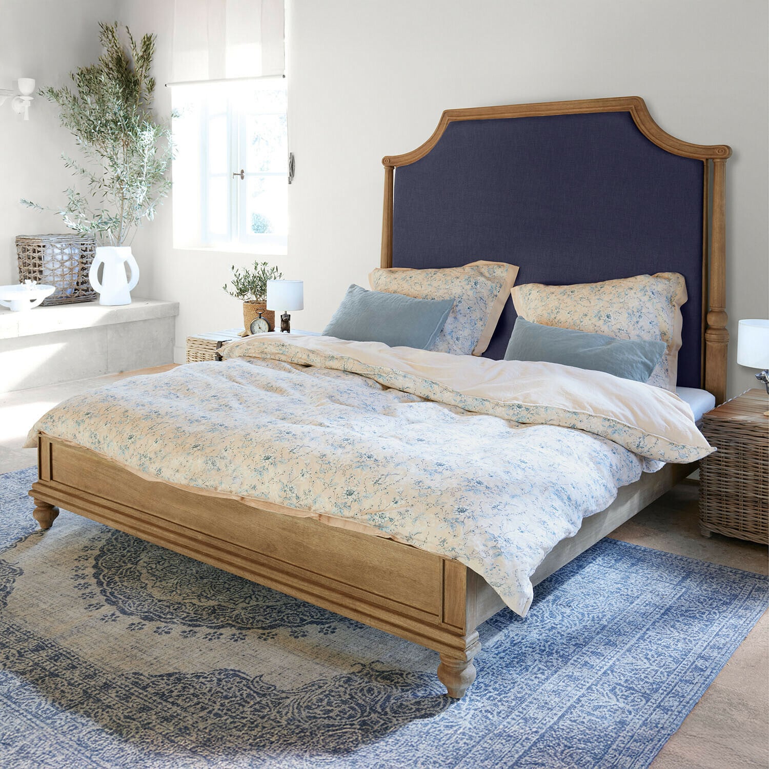 Letto Fairmontine Letto in legno con testiera imbottita blu scuro in camera luminosa con tappeto blu