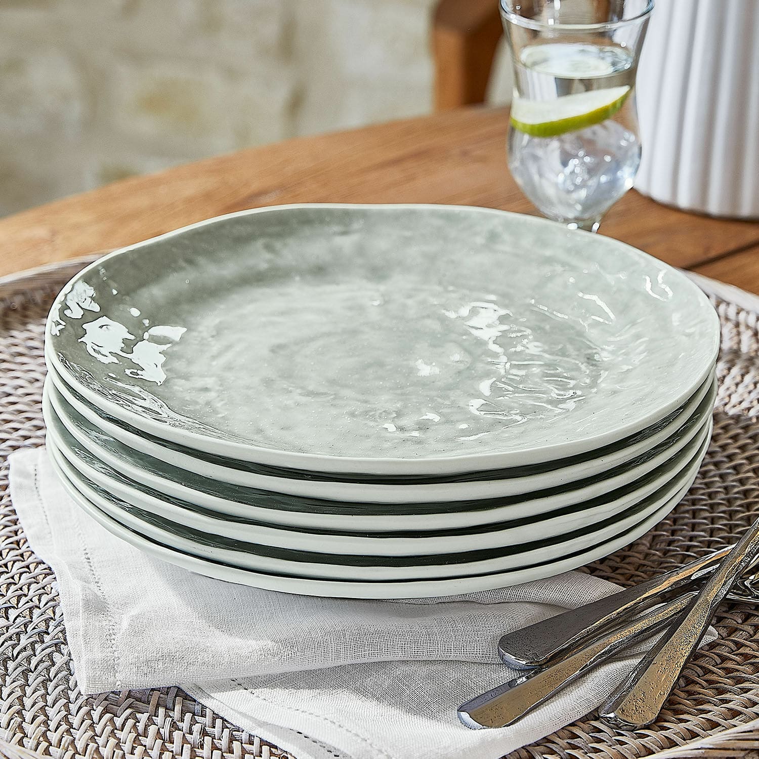 Set di 6 piatti Braganza Set di sei piatti in ceramica grigia su tovagliolo di lino con posate in metallo
