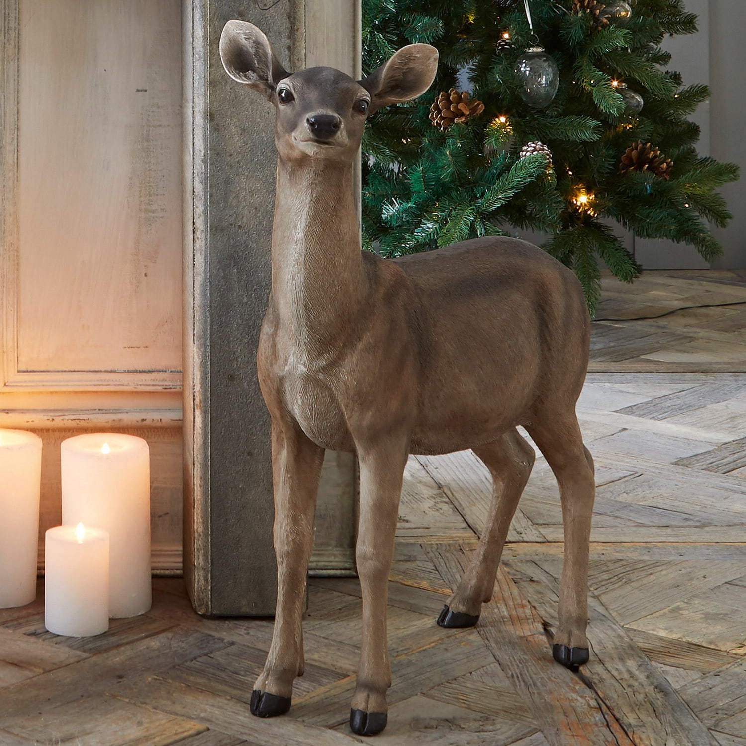 Capriolo Ruud Figura decorativa di cervo marrone davanti ad albero di Natale illuminato e candele