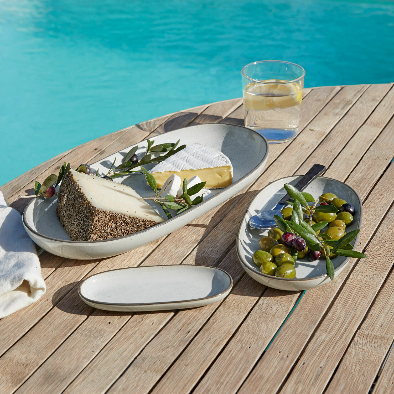 Set di 3 vassoi Biarré Set di piatti ovali in ceramica grigio chiaro su tavolo in legno con formaggio e olive