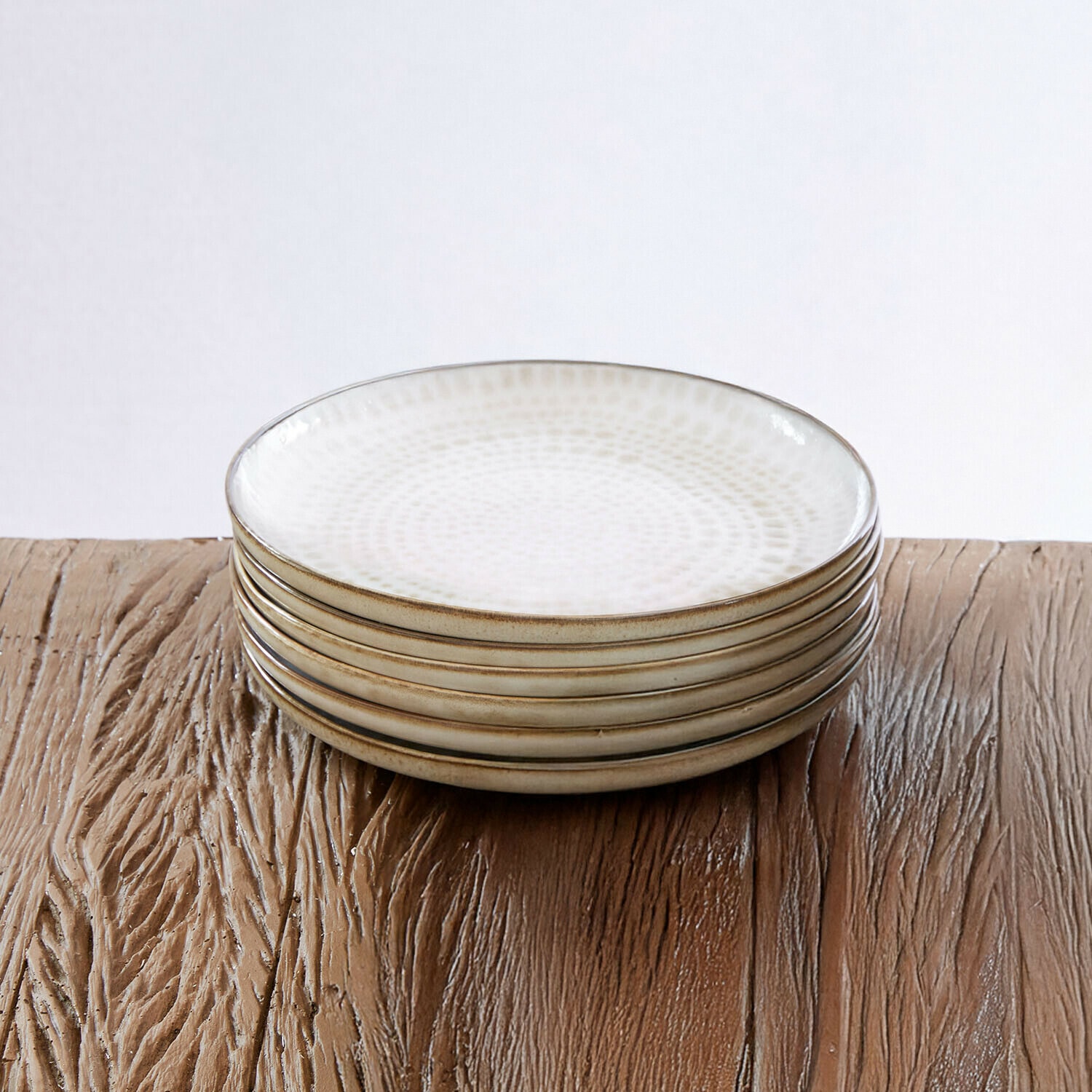Set di 6 piattini Marnis Set di sei piatti in ceramica bianca con motivo delicato e bordo marrone su tavolo in legno