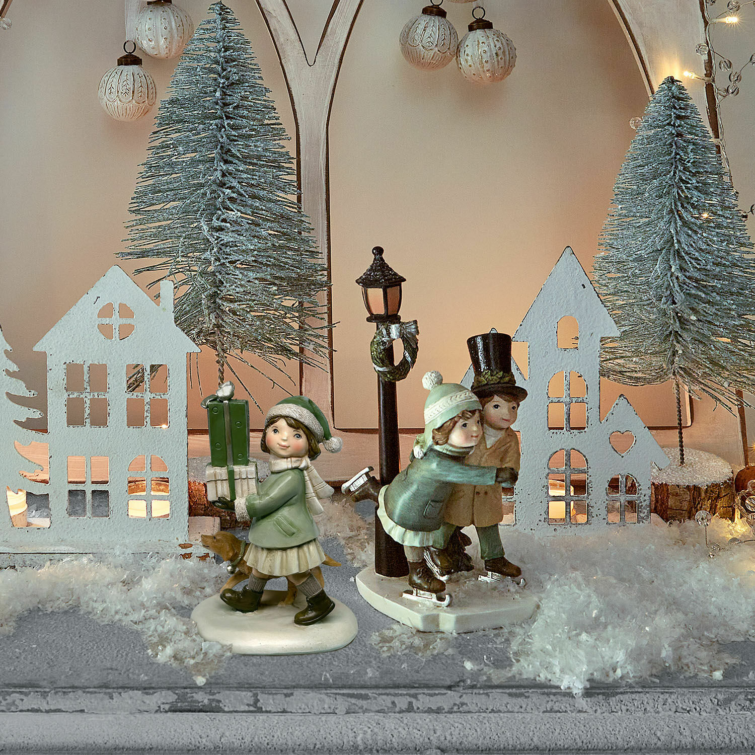 Coppia di statuette decorative Marquelline Decorazione invernale con statuine di bambini sul ghiaccio e casette in ambiente natalizio innevato