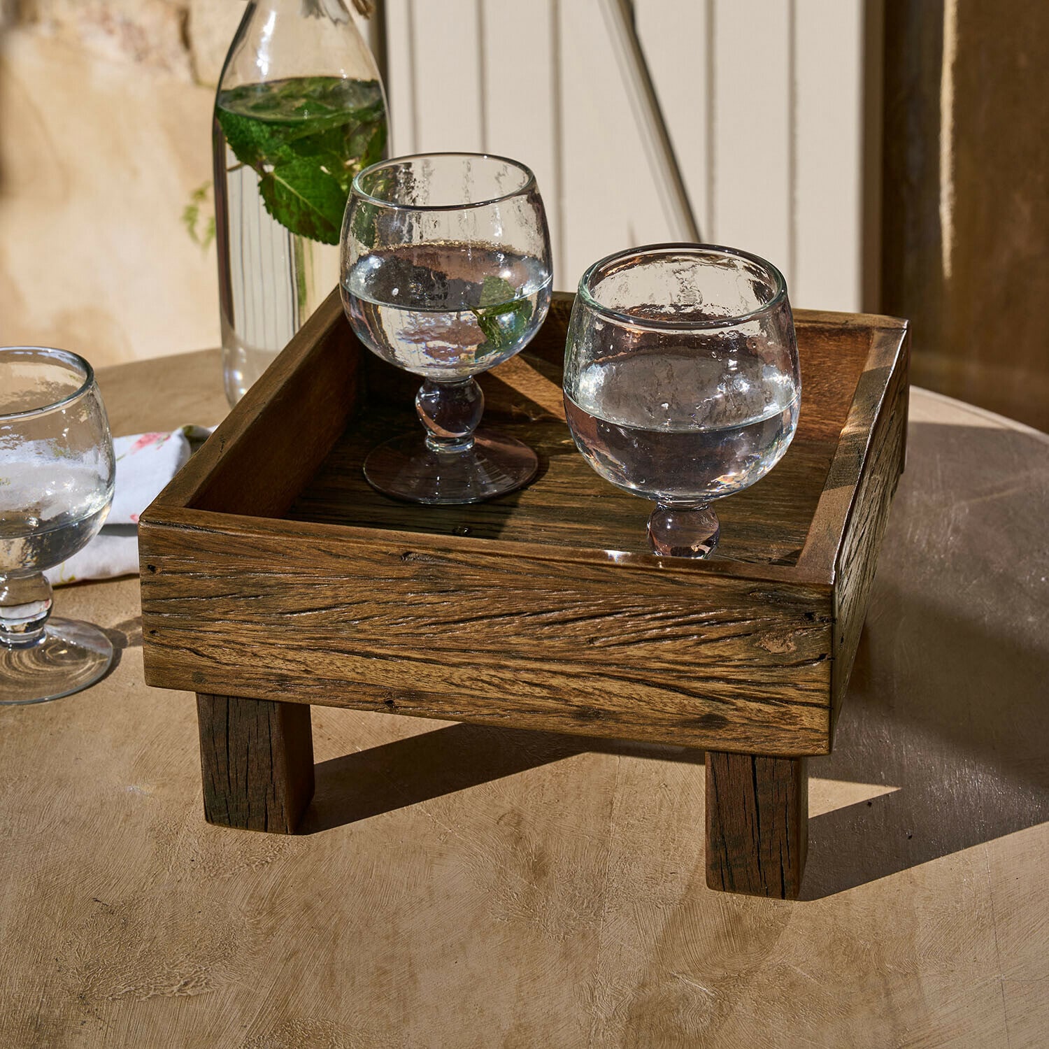 Vassoio Oldmere Vassoio in legno scuro con gambe con due bicchieri d'acqua e foglie di menta su tavolo