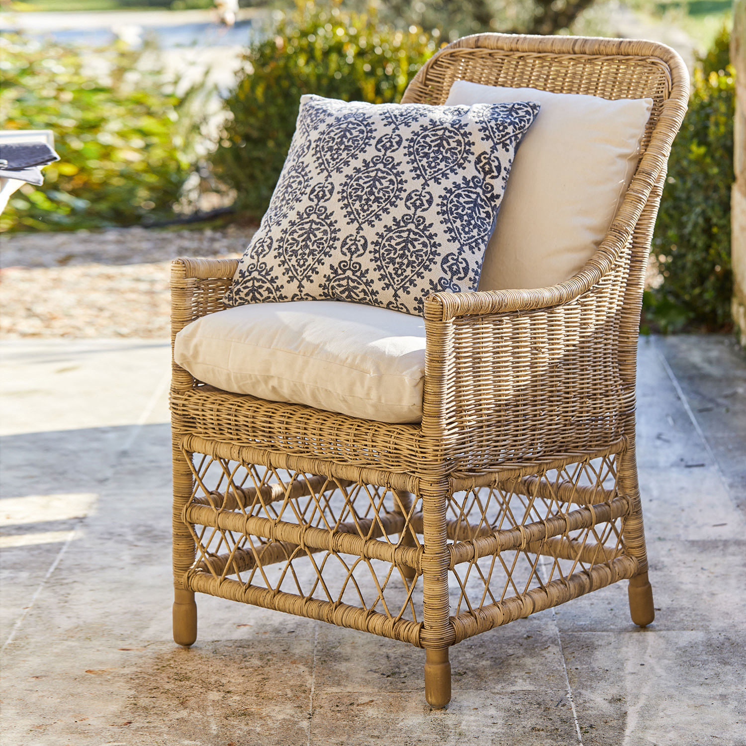 Poltrona Giepmare Poltrona in rattan con cuscini crema e cuscino decorativo blu, arredo da giardino elegante