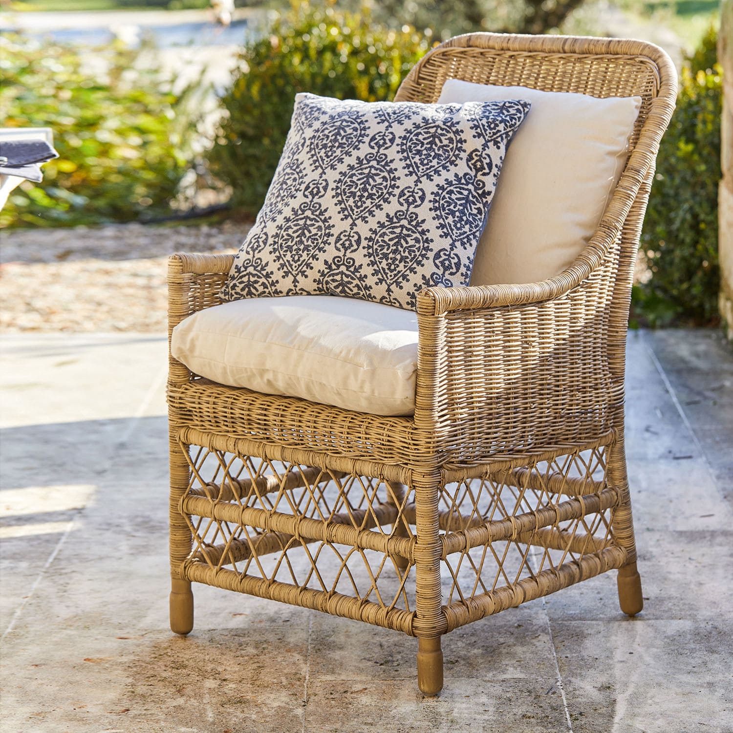 Poltrona Giepmare Poltrona in rattan con cuscini crema e cuscino decorativo blu, arredo da giardino elegante