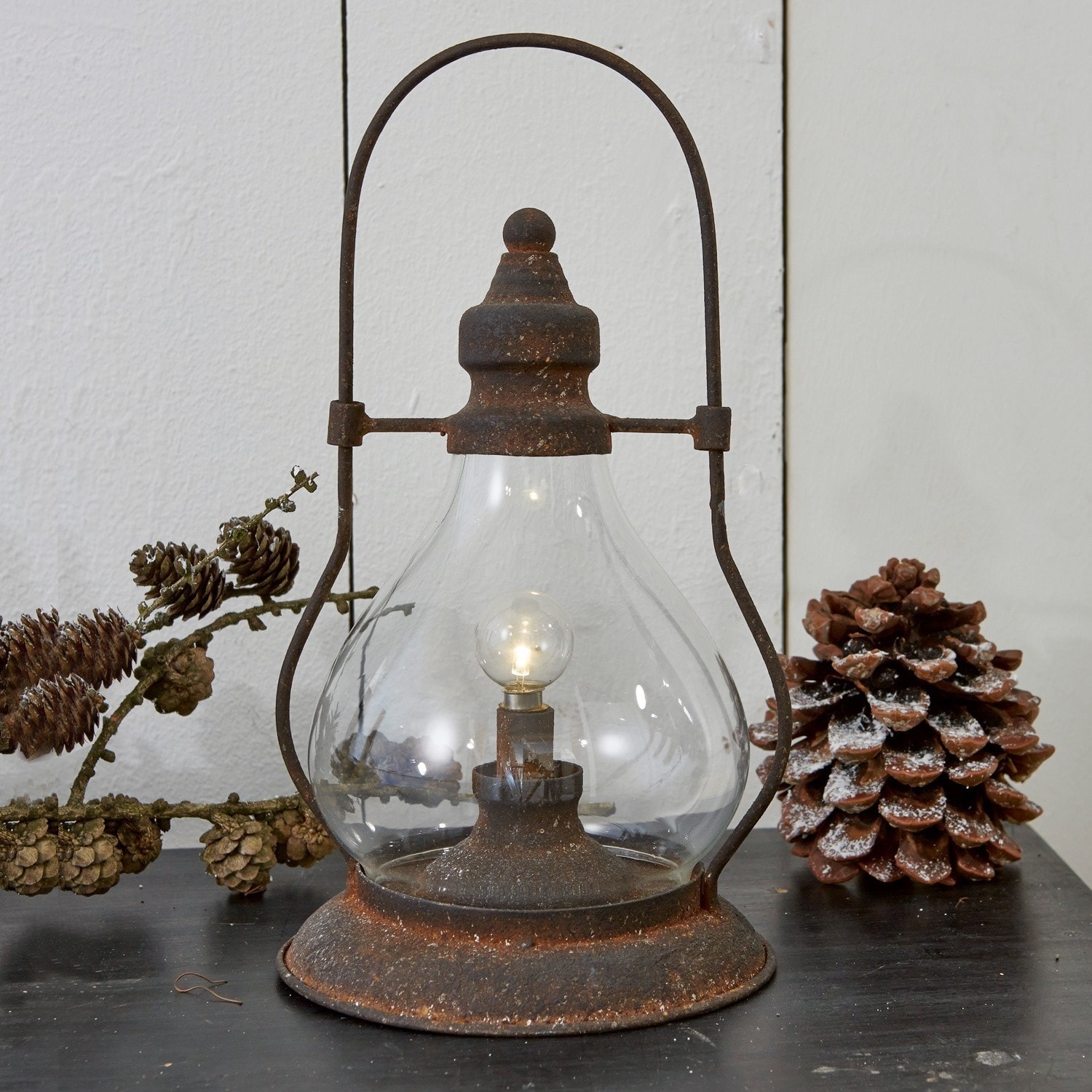 Lanterna a LED Cortney Lampada rustica in metallo arrugginito e vetro, lanterna decorativa su tavolo con pigne naturali
