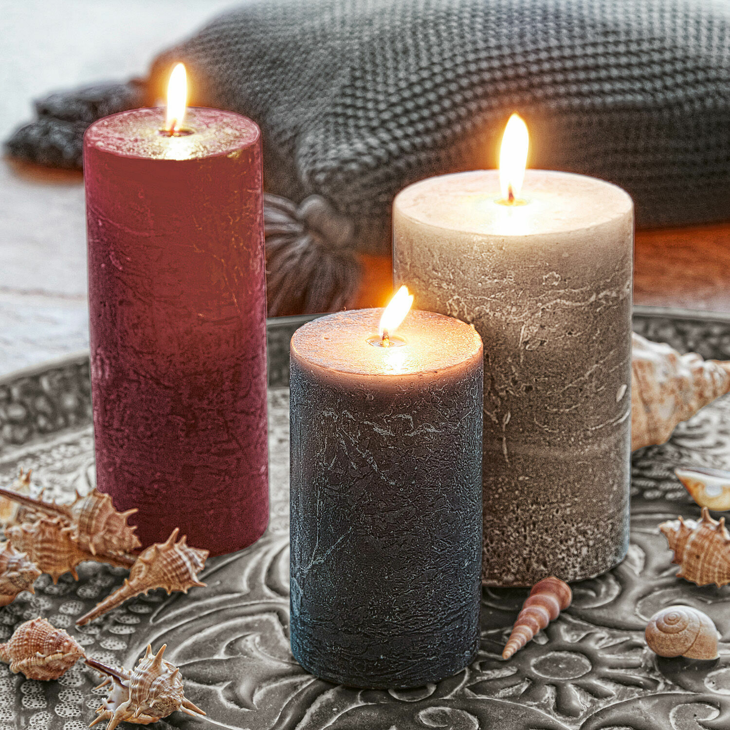 Set di 3 candele Pretin Tre candele decorative rosse, grigie e nere su un vassoio di metallo con conchiglie