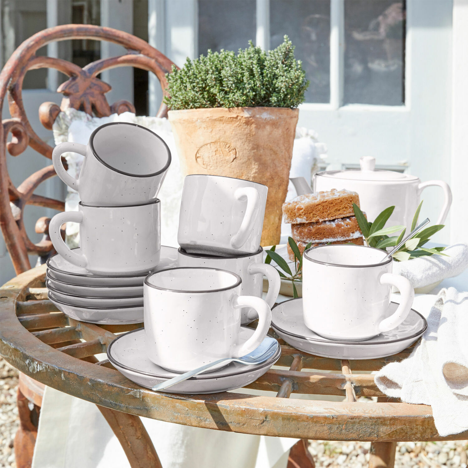 Set di 6 tazze con piattino Biarré Set di tazze in ceramica bianca con piattini su tavolo rustico da giardino con torta e vaso