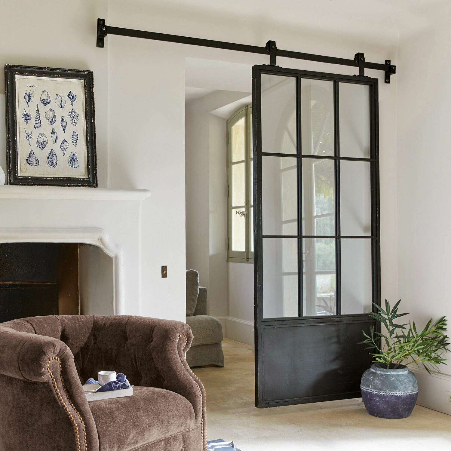 Porta scorrevole Luisant Porta scorrevole stile loft in metallo nero e vetro in interno moderno con poltrona e camino
