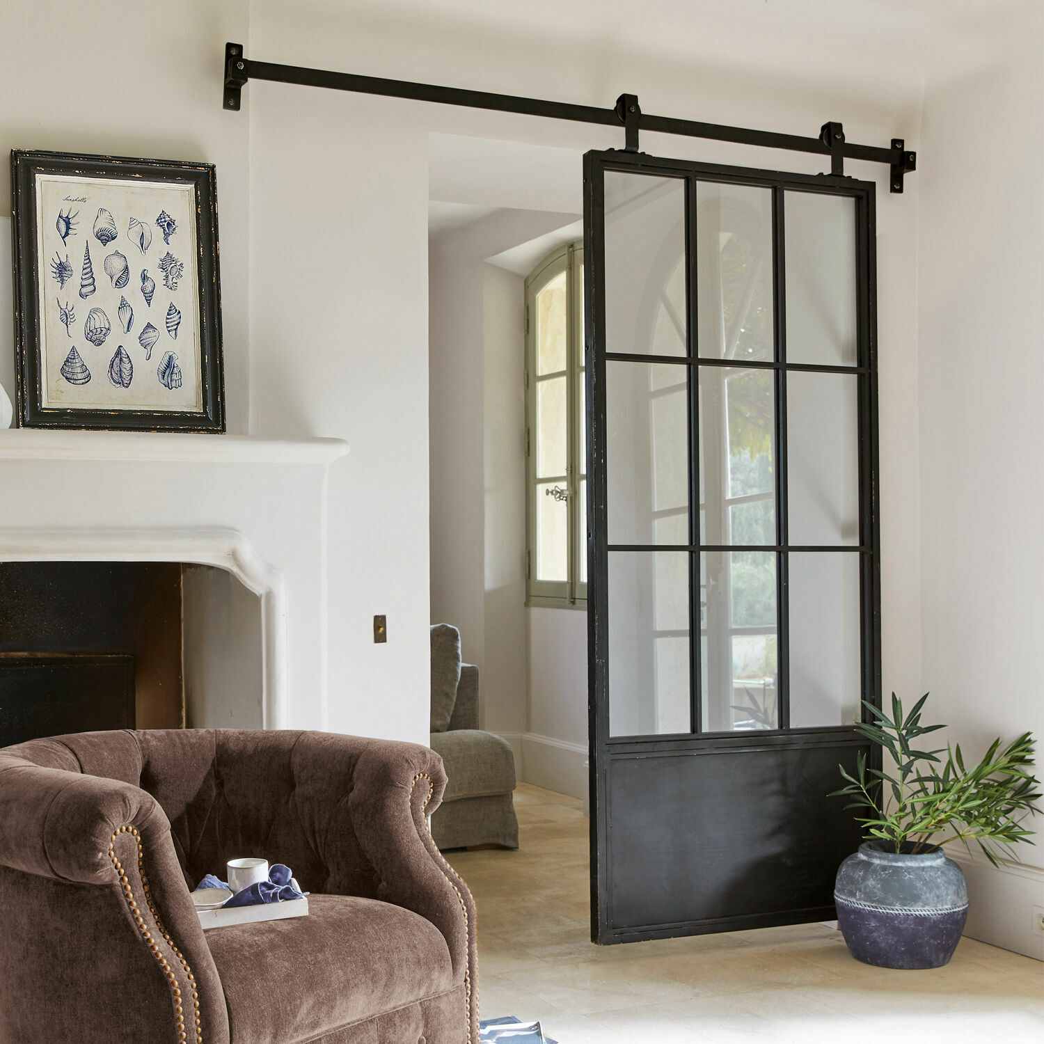 Porta scorrevole Luisant Porta scorrevole stile loft in metallo nero e vetro in interno moderno con poltrona e camino