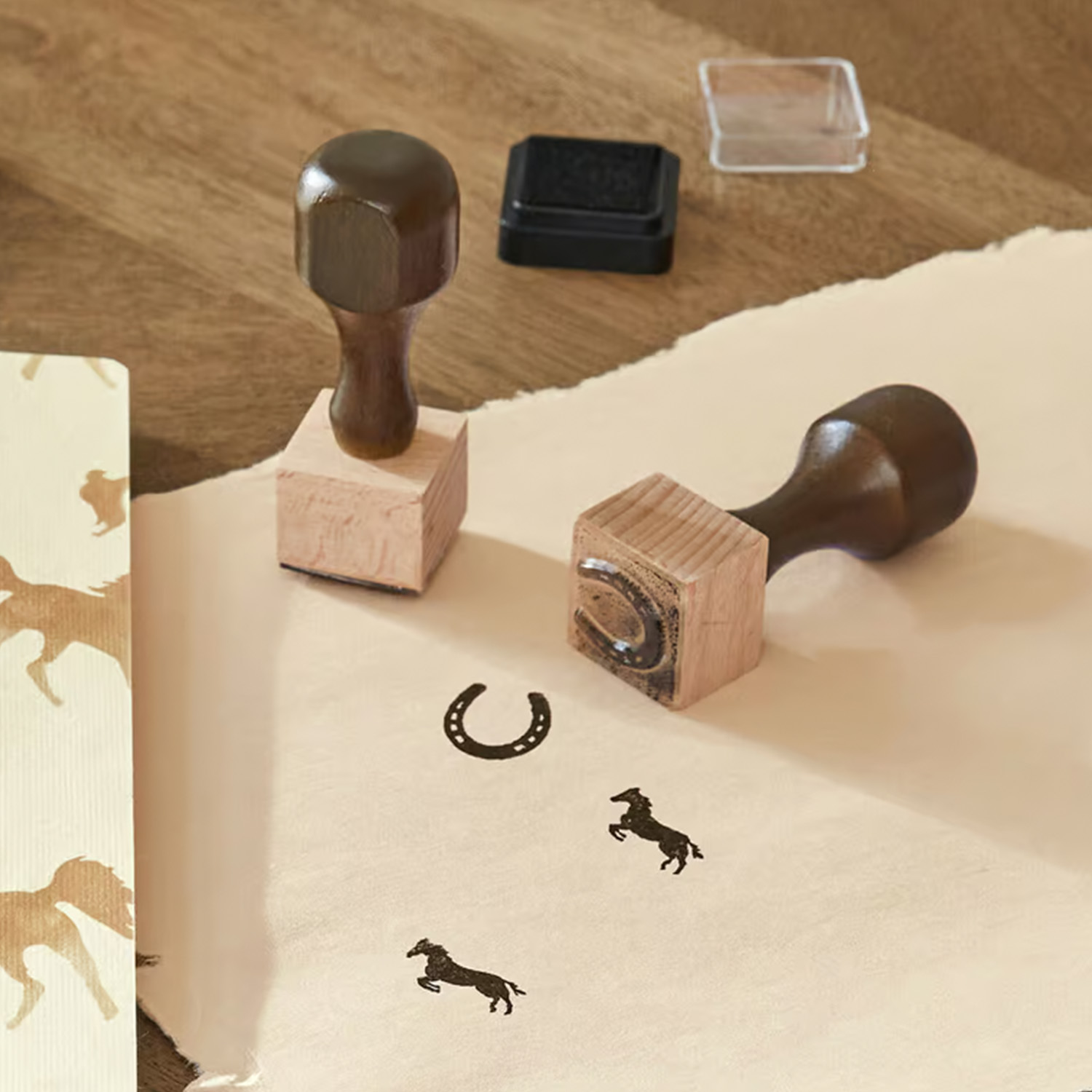 Timbri in legno con motivi di cavallo e ferro di cavallo su carta beige per decorazione