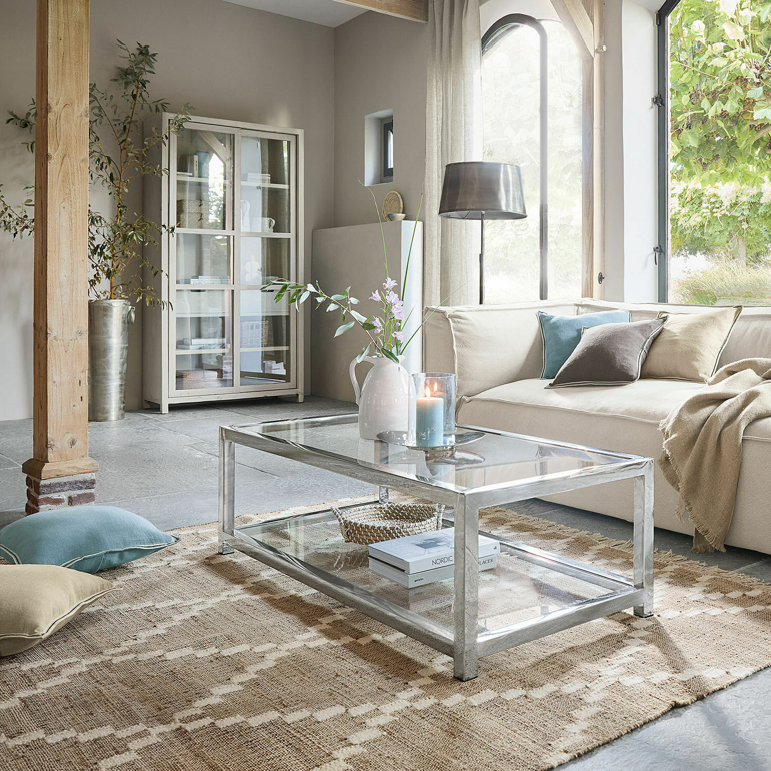 Tappeto per esterni e interni Piera Tavolino moderno in vetro con struttura metallica in soggiorno luminoso con divano beige e decorazioni