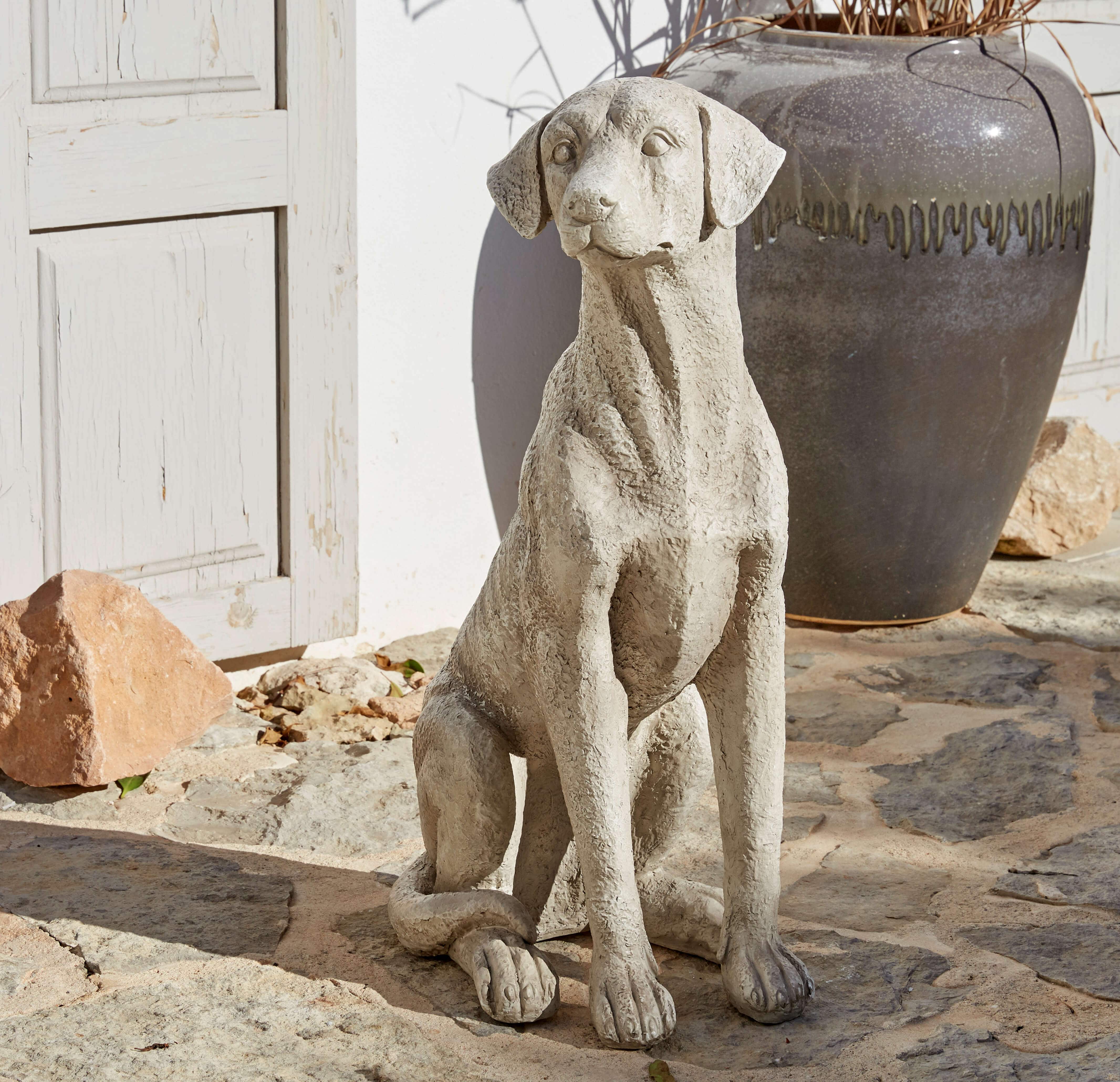 Scultura di cane in cemento grigio su pavimento in pietra, decorazione da giardino