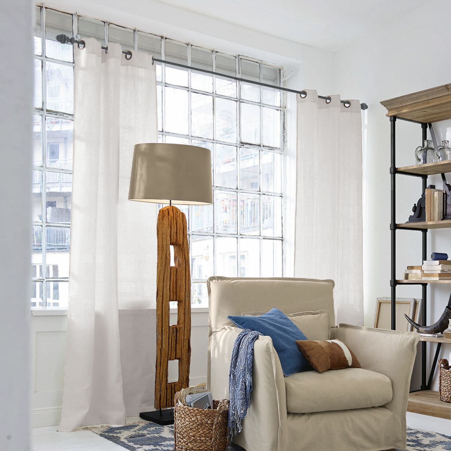 Tenda Salinas Lampada da terra con base in legno e paralume beige in soggiorno luminoso con poltrona e scaffale