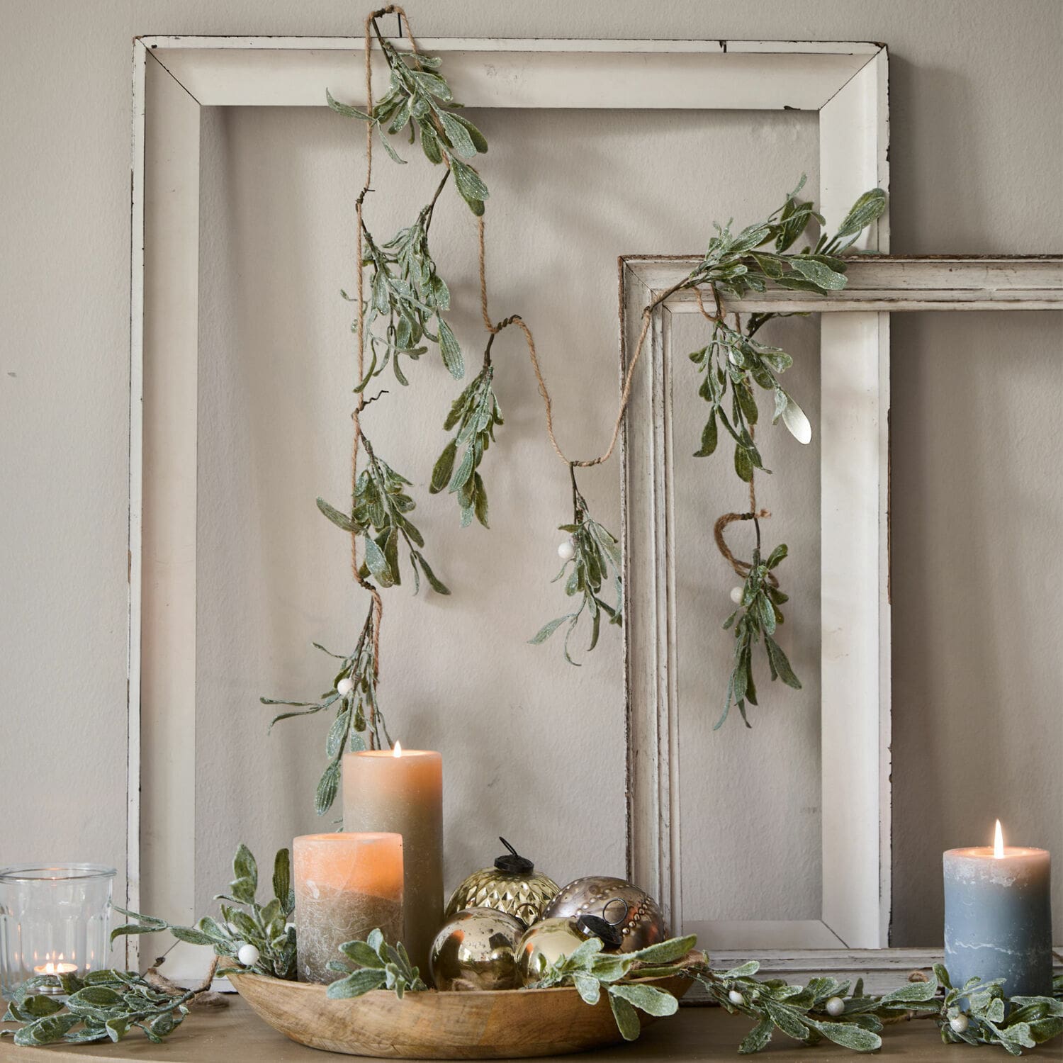 Festone Mistletoe Ghirlanda decorativa con foglie verdi e bacche bianche su cornici di legno bianche, candele e decorazioni